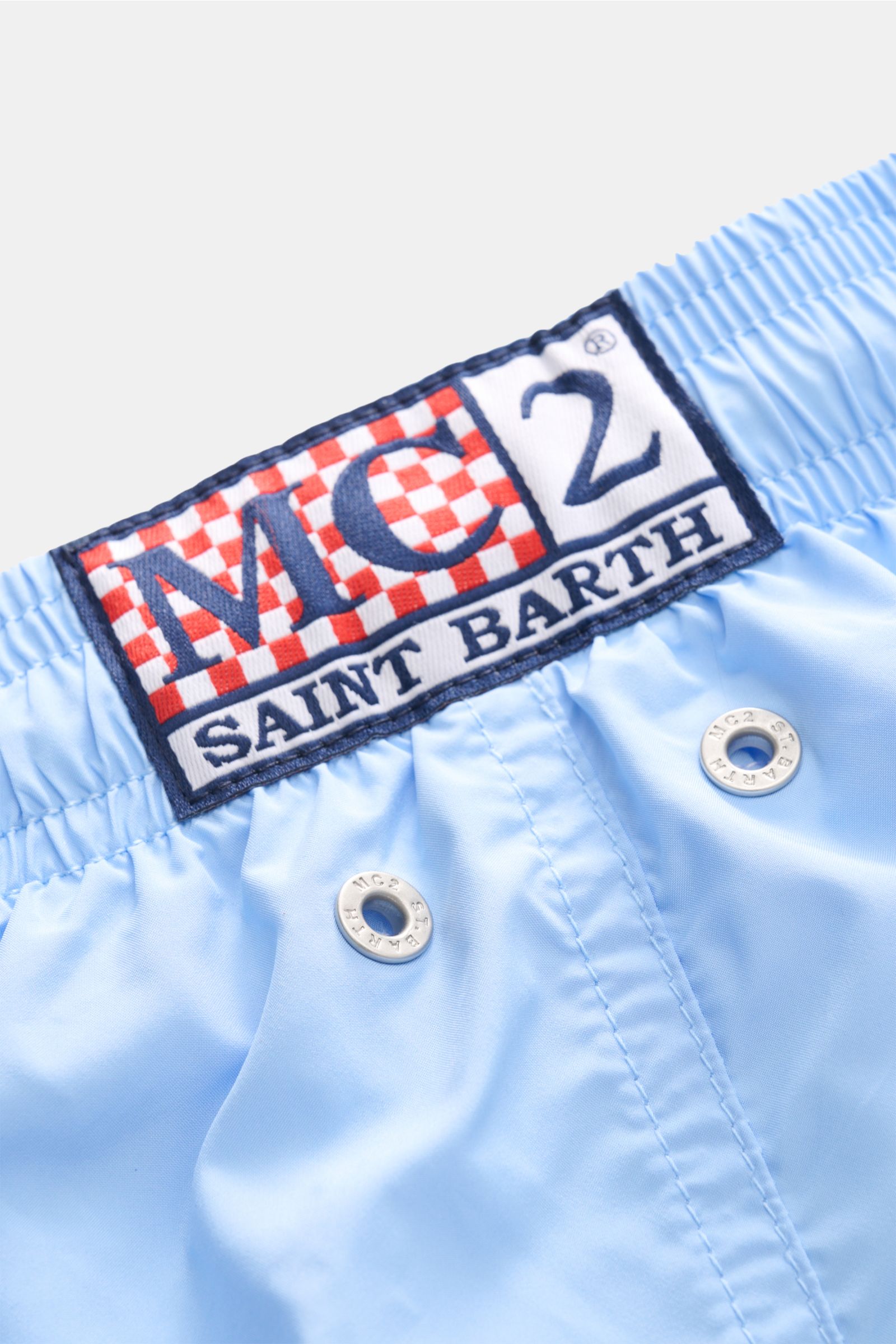 Nahaufnahme der hellblauen MC2 Saint Barth Badeshorts 'Lightning Pantone' von oben mit elastischem Bund, Metallösen und Label.