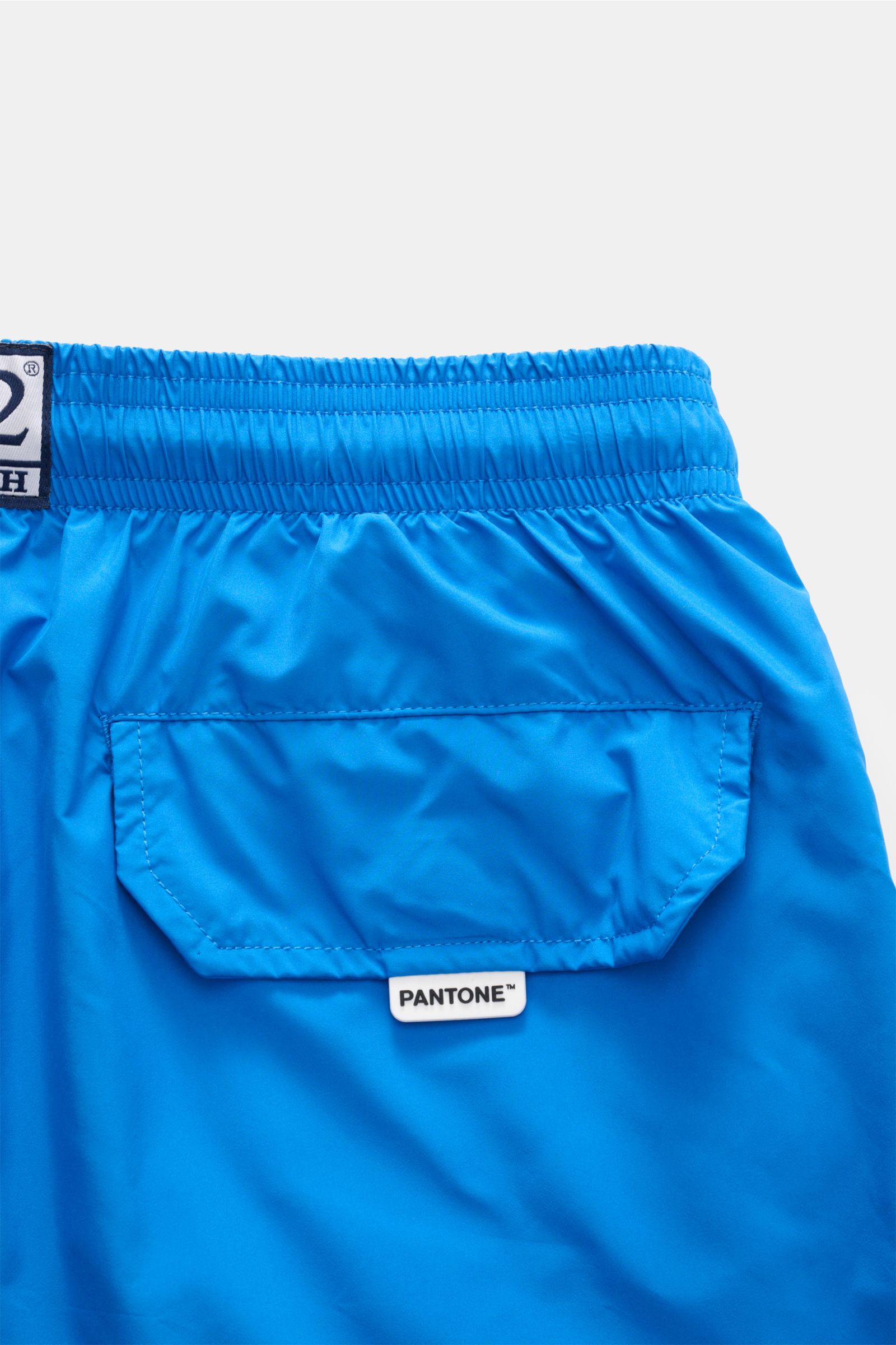 Nahaufnahme der Rückseite der MC2 Saint Barth Badeshorts 'Lightning Pantone' blau mit elastischem Bund, Tasche und Pantone-Label.