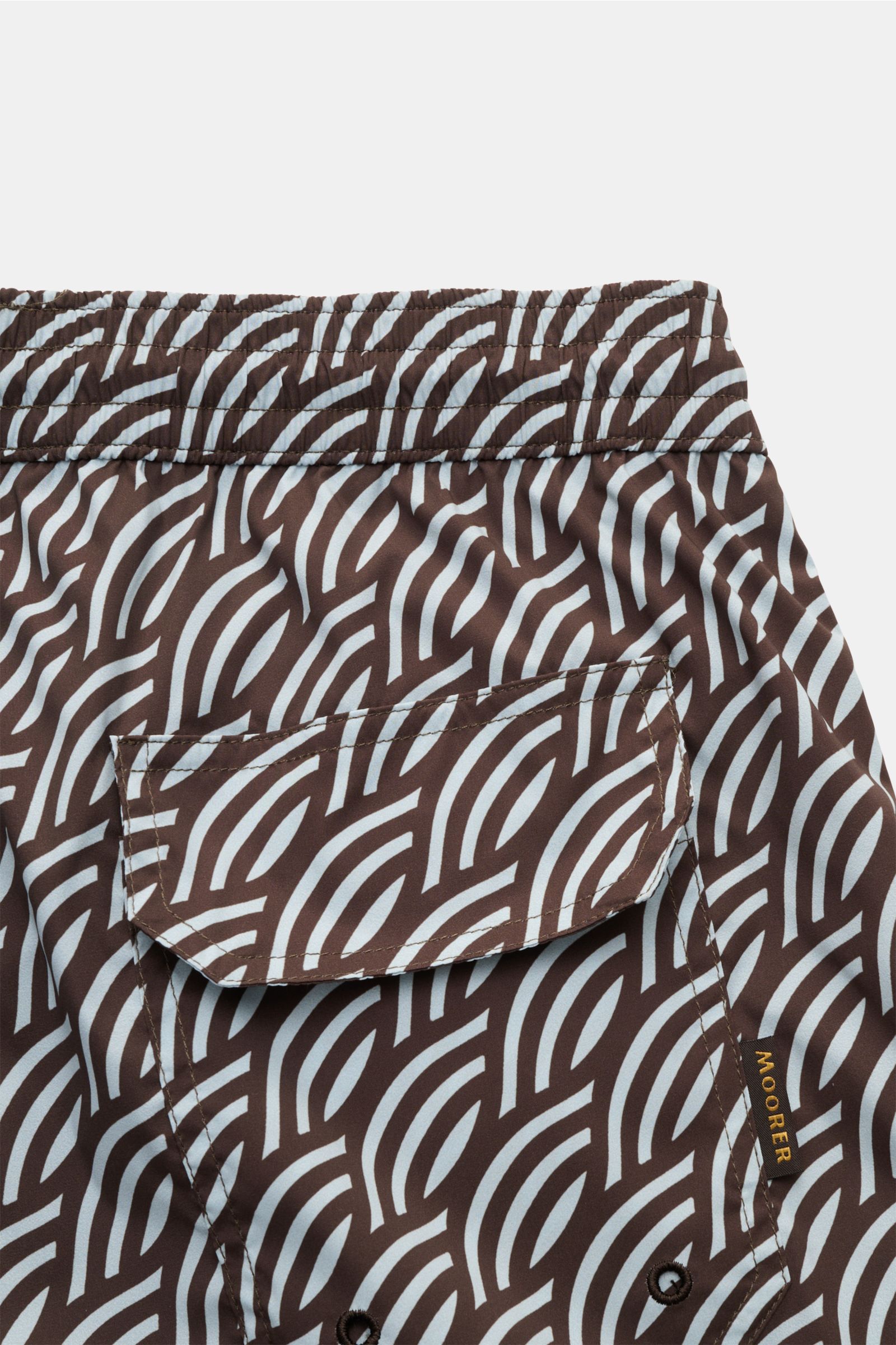 Close-up rear view of Moorer Swim shorts dark brown/smoky blue patterned, showing elasticated waistband with drawstring, back pocket with flap, quick-drying microfibre, smooth feel, regular fit, small key pocket inside, side seam pockets, and smooth linin