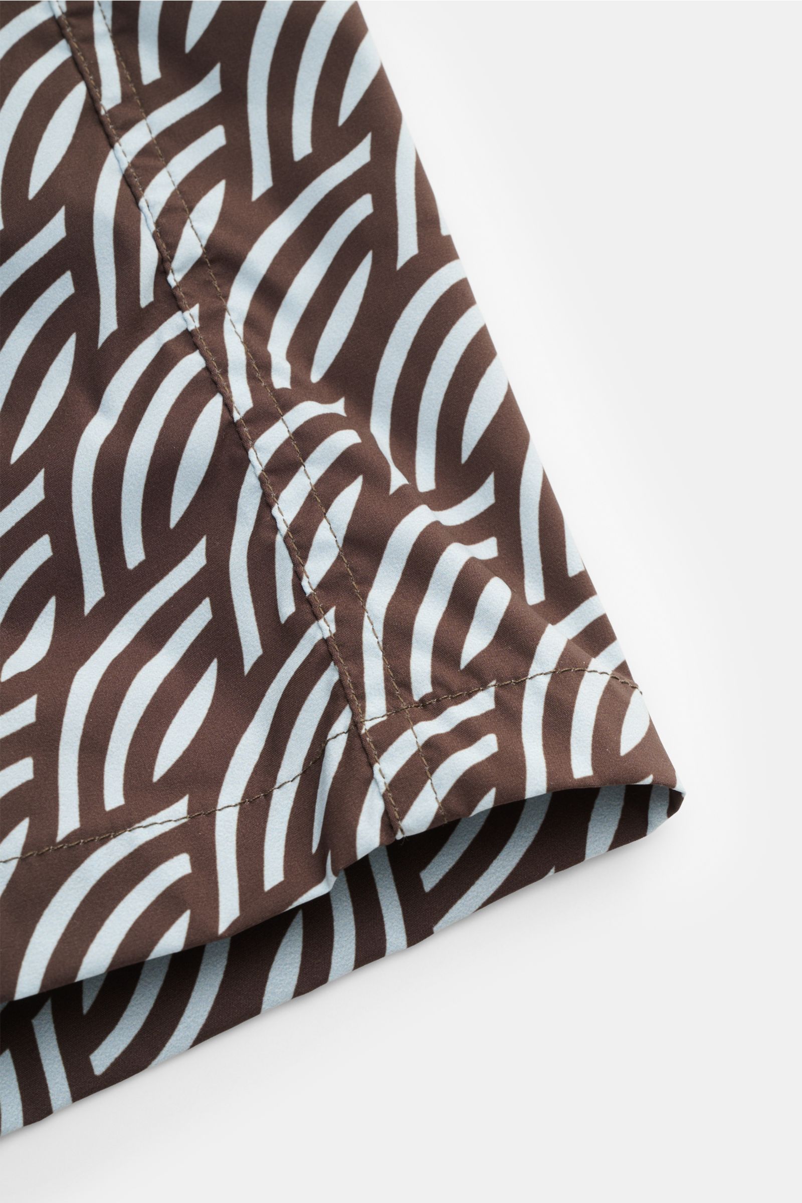 Close-up side view of Moorer Swim shorts dark brown/smoky blue patterned, showing fabric and stitching details. Features quick-drying microfibre, smooth feel, regular fit, elasticated waistband with drawstring, small key pocket inside, side seam pockets, 