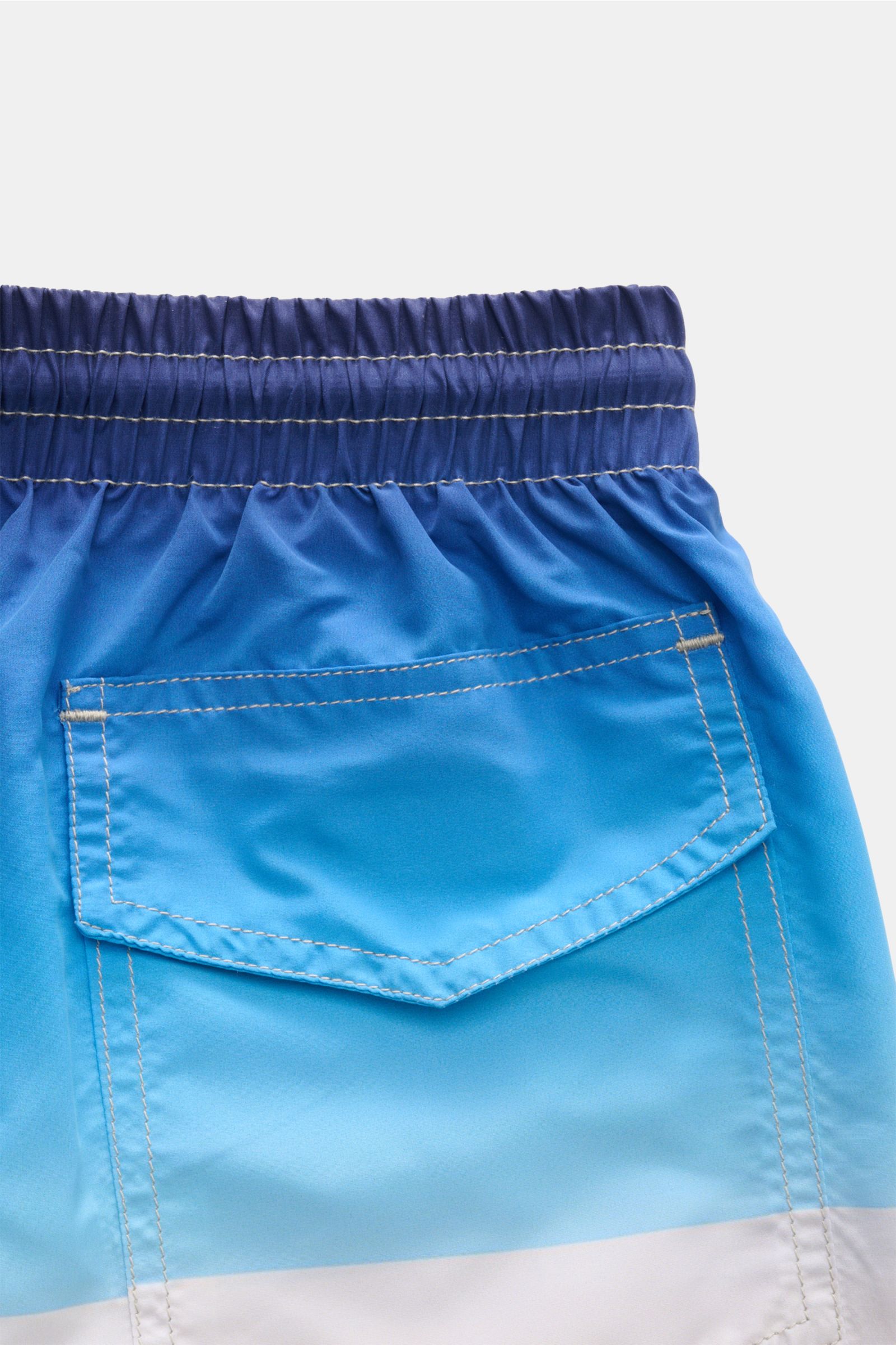 Zeybra Portofino 1962 Badeshorts 'Villa' blau/offwhite/türkis shown from a close-up rear view, highlighting elastic waistband and back pocket. Sommerliches Statement: Mit ihrem markanten Allover-Print werden die Badeshorts von ZEYBRA PORTOFINO 1962 zum Bl