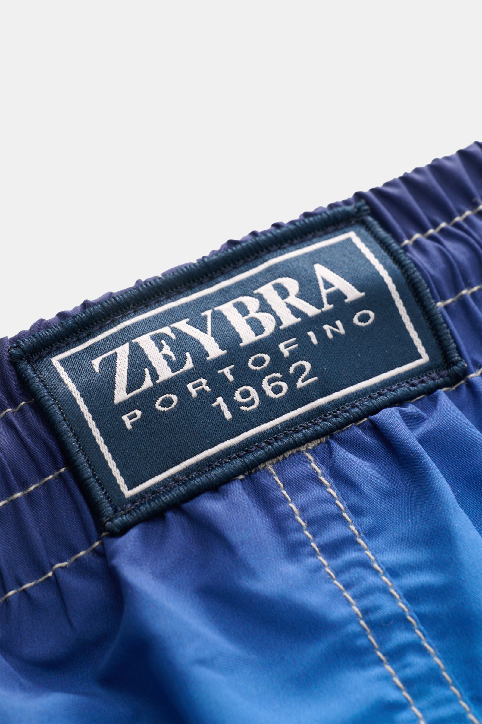 Close-up image of the waistband and label of the Zeybra Portofino 1962 Badeshorts 'Villa' blau/offwhite/türkis, photographed from above. Sommerliches Statement: Mit ihrem markanten Allover-Print werden die Badeshorts von ZEYBRA PORTOFINO 1962 zum Blick