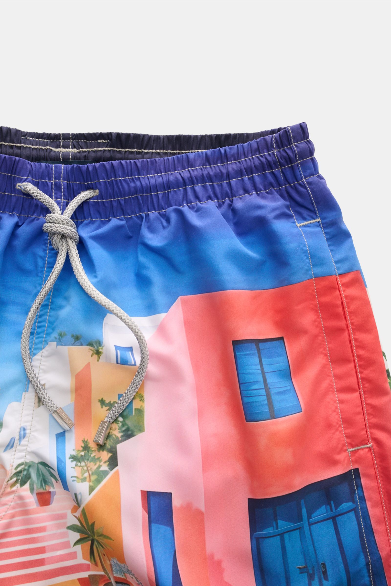 Close-up front view of Zeybra Portofino 1962 Badeshorts 'Lisbona' multicolor featuring a vibrant coastal print, elastic waistband with drawstring.

Sommerliches Statement: Mit ihrem markanten Print werden die Badeshorts von ZEYBRA PORTOFINO 1962 zum Bl