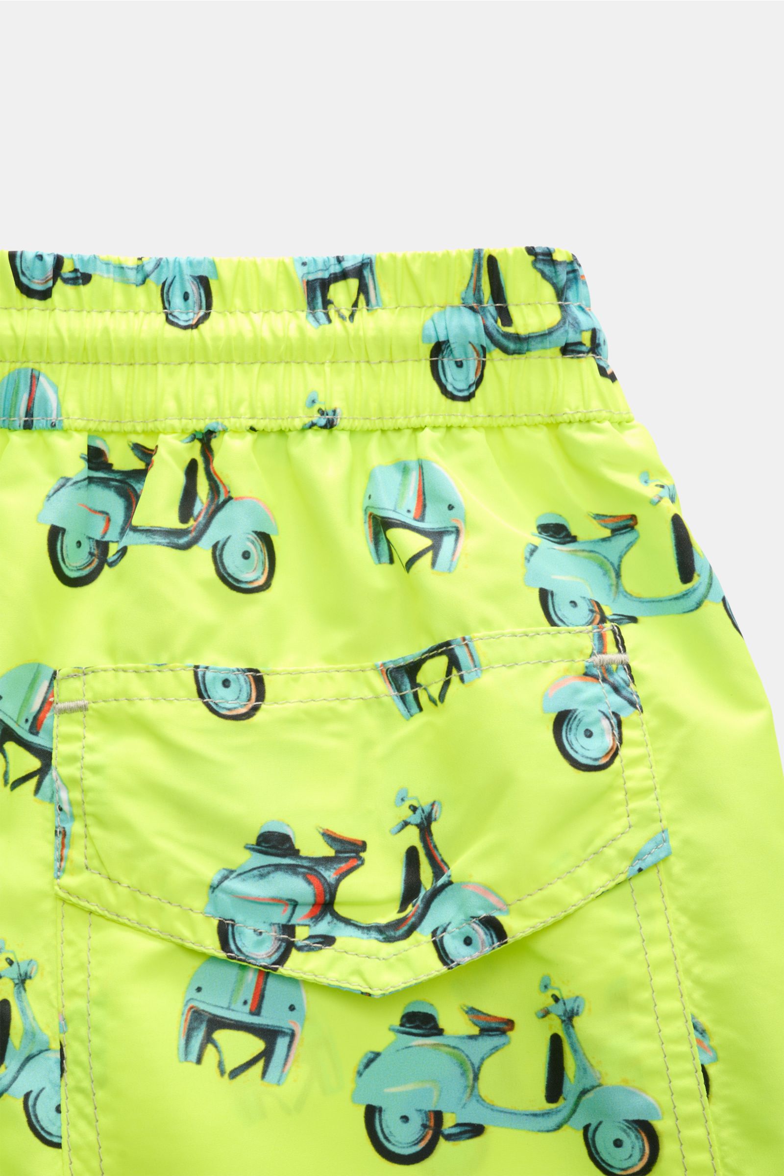 Close-up rear view of Zeybra Portofino 1962 Badeshorts 'Scooter' neongelb/hellblau gemustert with elastic waistband, back pocket, and scooter print.

Sommerliches Statement: Mit ihrem markanten Allover-Print werden die Badeshorts von ZEYBRA PORTOFINO 1