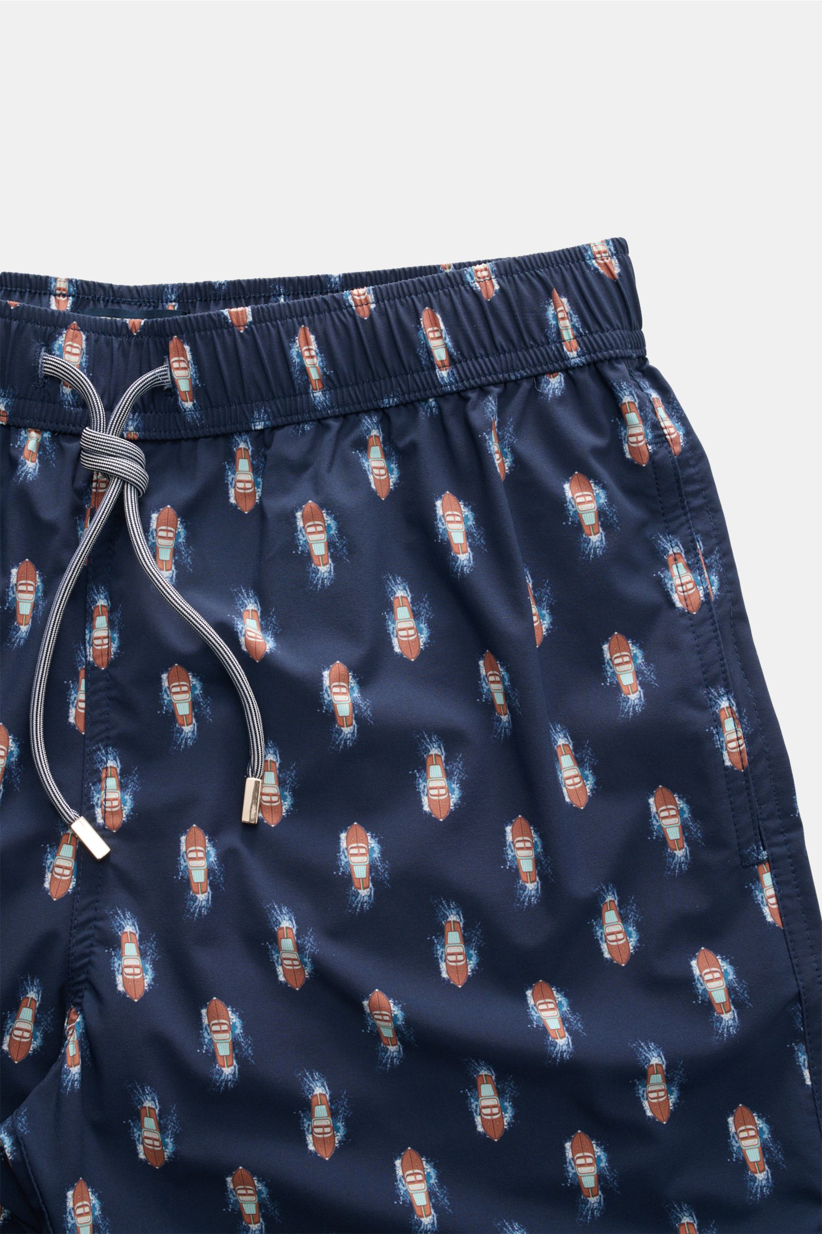 Close-up front view of Zeybra Portofino 1962 Badeshorts 'Boat' navy/braun gemustert with elastic waistband, drawstring, and boat print.  
Eyecatcher für sonnige Tage: Die Badeshorts von ZEYBRA PORTOFINO 1962 überzeugen mit kurzem Schnitt und auffällige