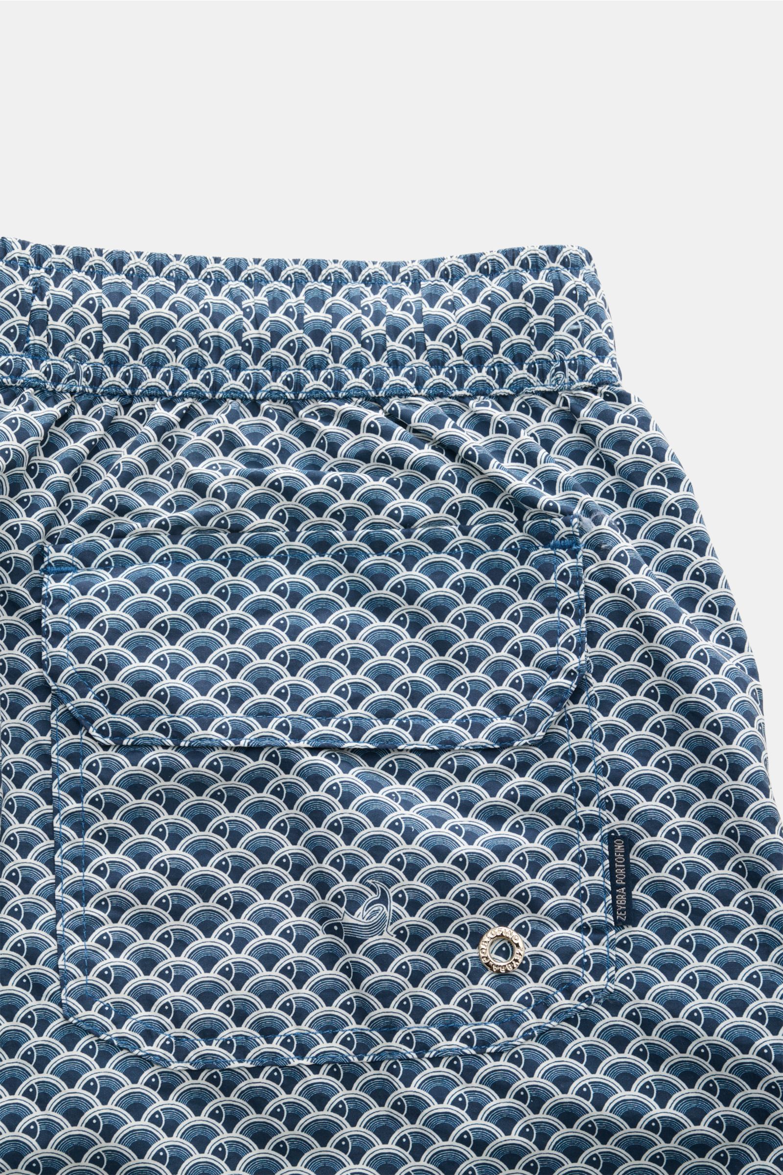 Nahaufnahme aus seitlicher Perspektive der Zeybra Portofino 1962 Badeshorts dark navy/offwhite gemustert mit elastischem Bund, Gesäßtasche mit Klettverschluss und grafischem Print.