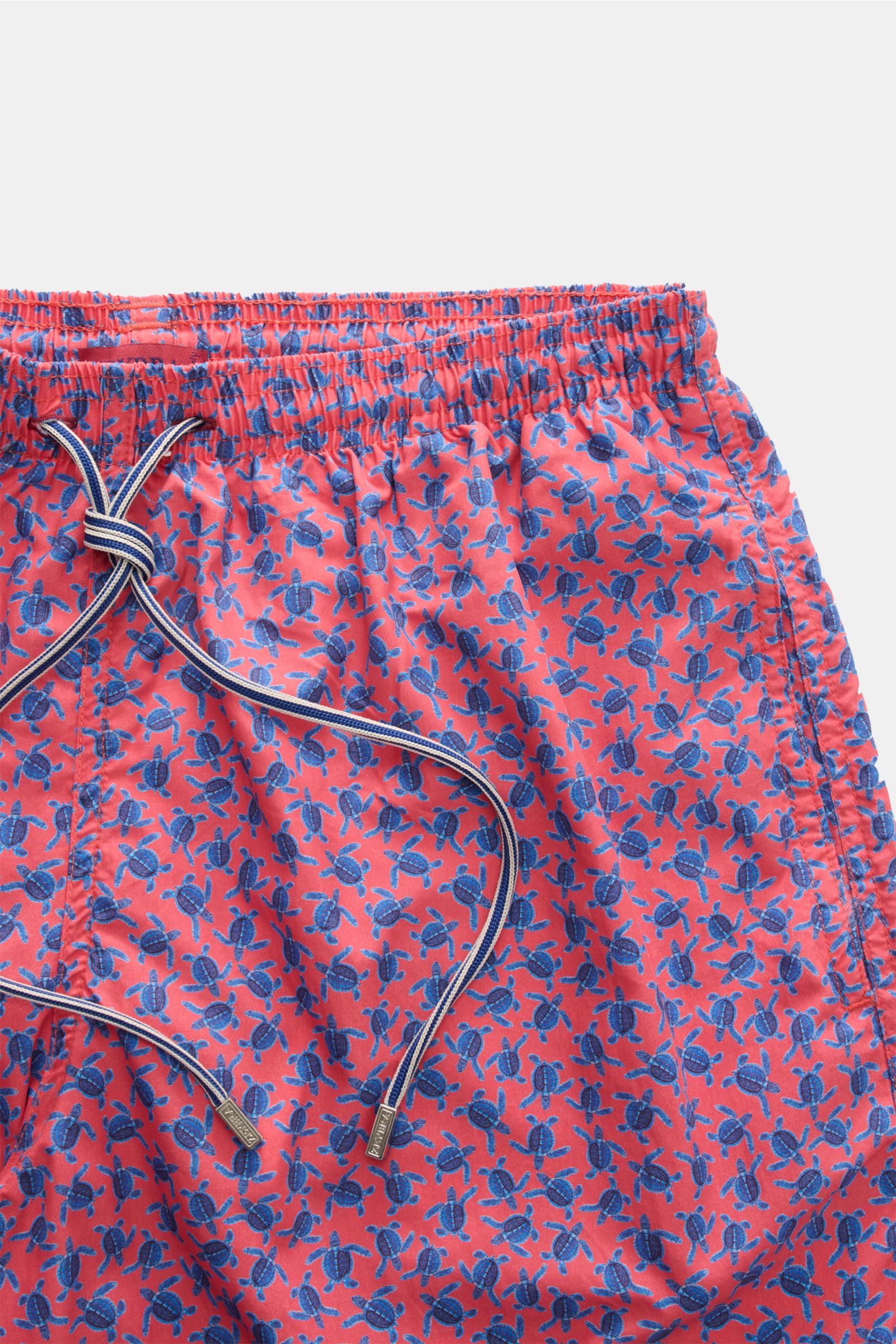 Close-up front view of Zeybra Portofino 1962 Badeshorts 'Tatarughe' rot/blau gemustert with red base and blue turtle print, elastic waistband, and drawstring. Eyecatcher für sonnige Tage: Die Badeshorts von ZEYBRA PORTOFINO 1962 überzeugen mit kurzem Schn
