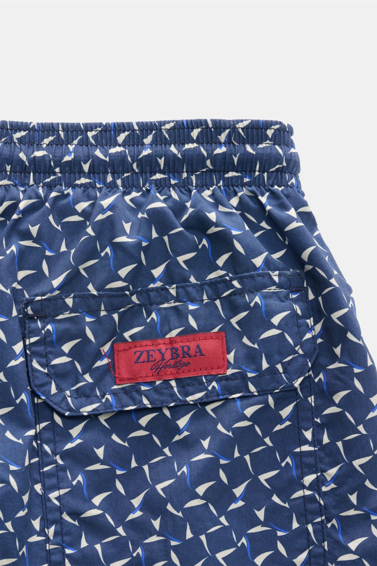 Close-up view of the elastic waistband and back pocket of the Zeybra Portofino 1962 Badeshorts 'Foulard' navy/hellgrau/blau gemustert, featuring a graphic print and red brand label. Ausdrucksstarker Beach-Look: Die Badeshorts von ZEYBRA PORTOFINO 1962 ver