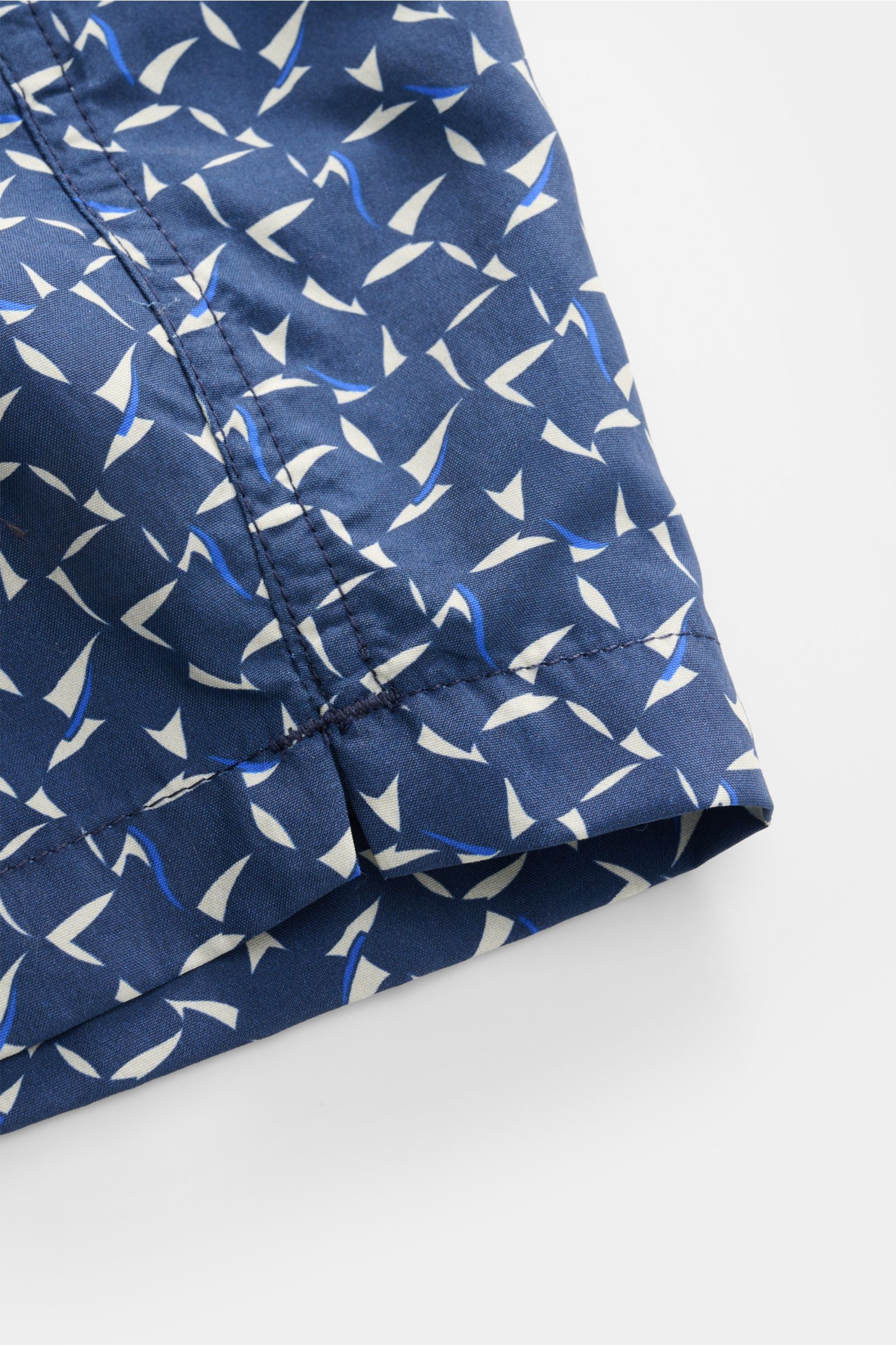 Close-up view of the hem and seam details of Zeybra Portofino 1962 Badeshorts 'Foulard' navy/hellgrau/blau gemustert, featuring a graphic print on smooth microfiber fabric. Ausdrucksstarker Beach-Look: Die Badeshorts von ZEYBRA PORTOFINO 1962 verbinden