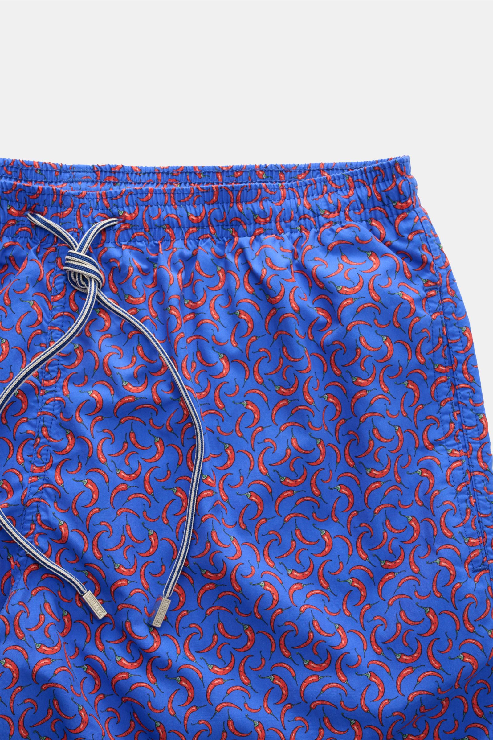 Zeybra Portofino 1962 Badeshorts 'Peperoncini' blau/rot gemustert shown from front close-up, short cut, bold chili print. Eyecatcher for sunny days: swim shorts with high-quality microfiber, smooth feel, regular fit, elastic waistband with drawstring, sid