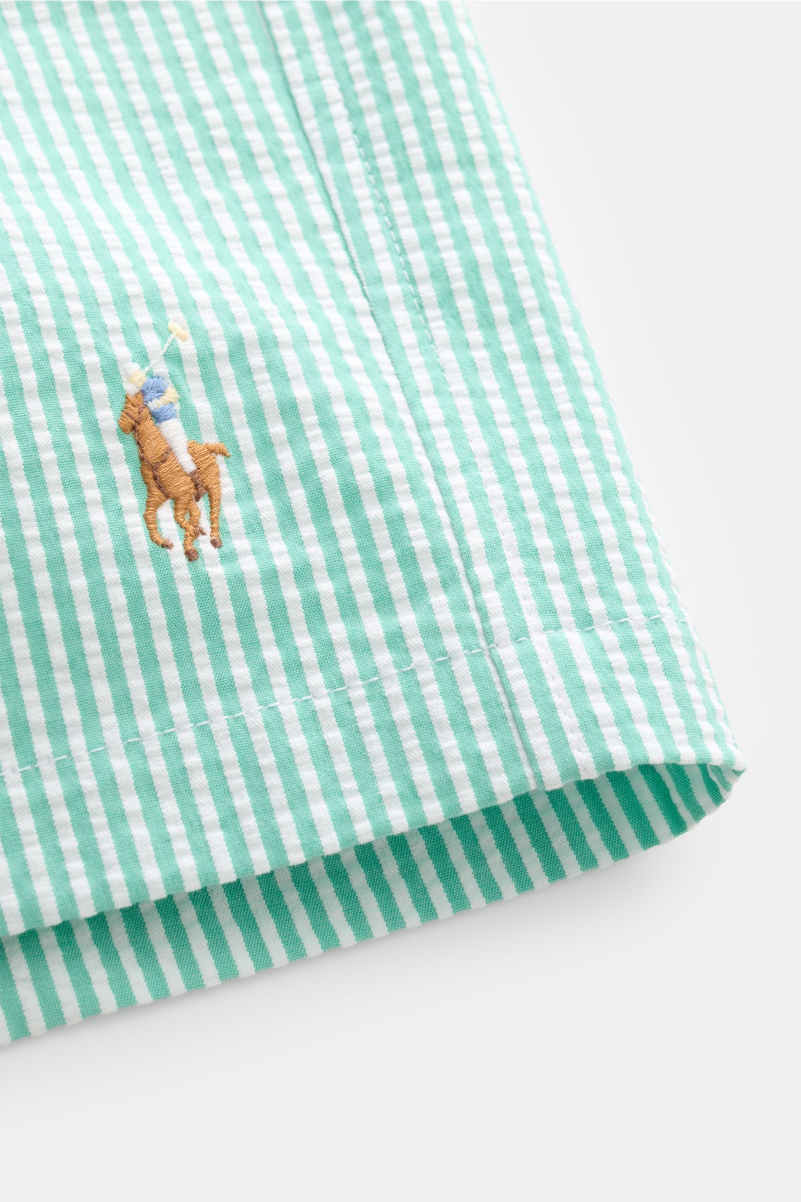 Nahaufnahme von Polo Ralph Lauren Seersucker-Badeshorts 'Traveler' mint/weiß gestreift mit Logo-Stitching, aus Baumwolle, Regular Fit, elastischem Bund, Seiten- und Gesäßtasche.