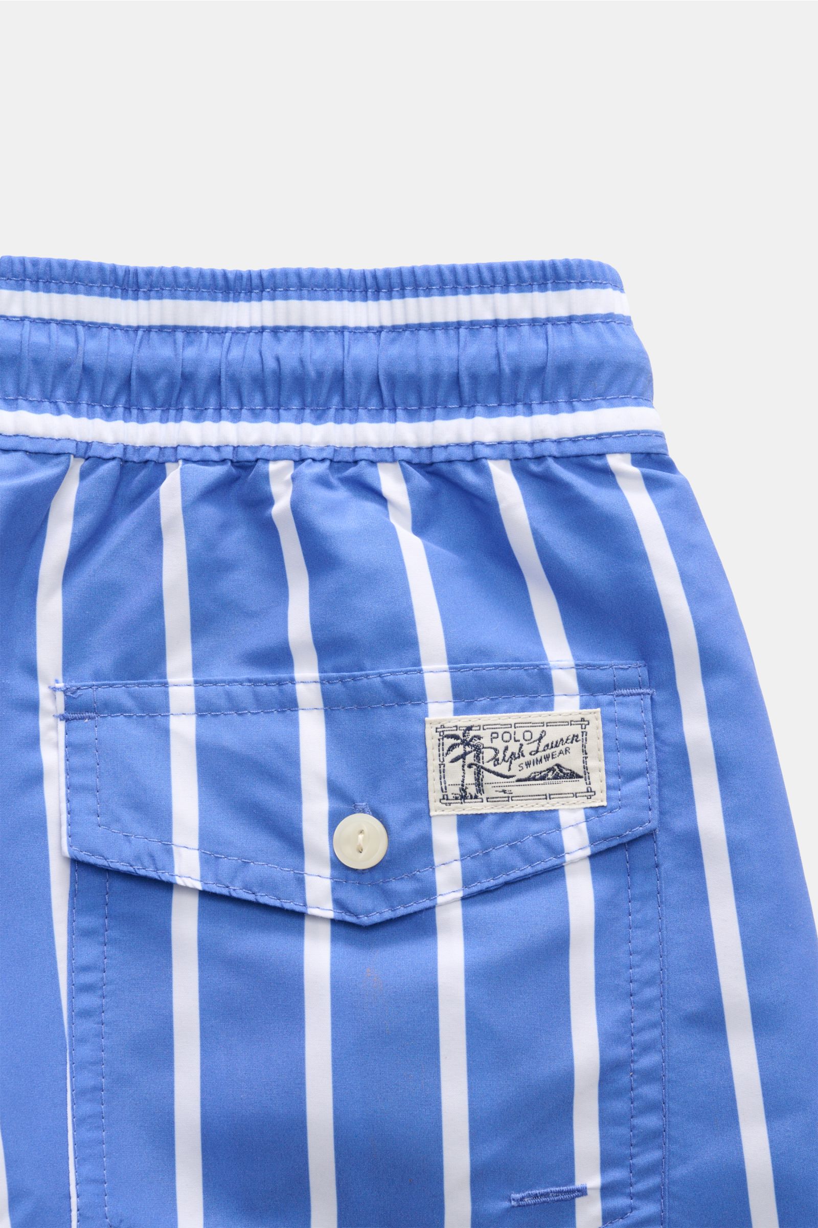 Close-up rear view of Polo Ralph Lauren Swim shorts 'Traveler' blue/white striped, showing elastic waistband, back pocket with button flap, and logo patch.

Description: Stylish confidence for your travels: These POLO RALPH LAUREN swim shorts are the p
