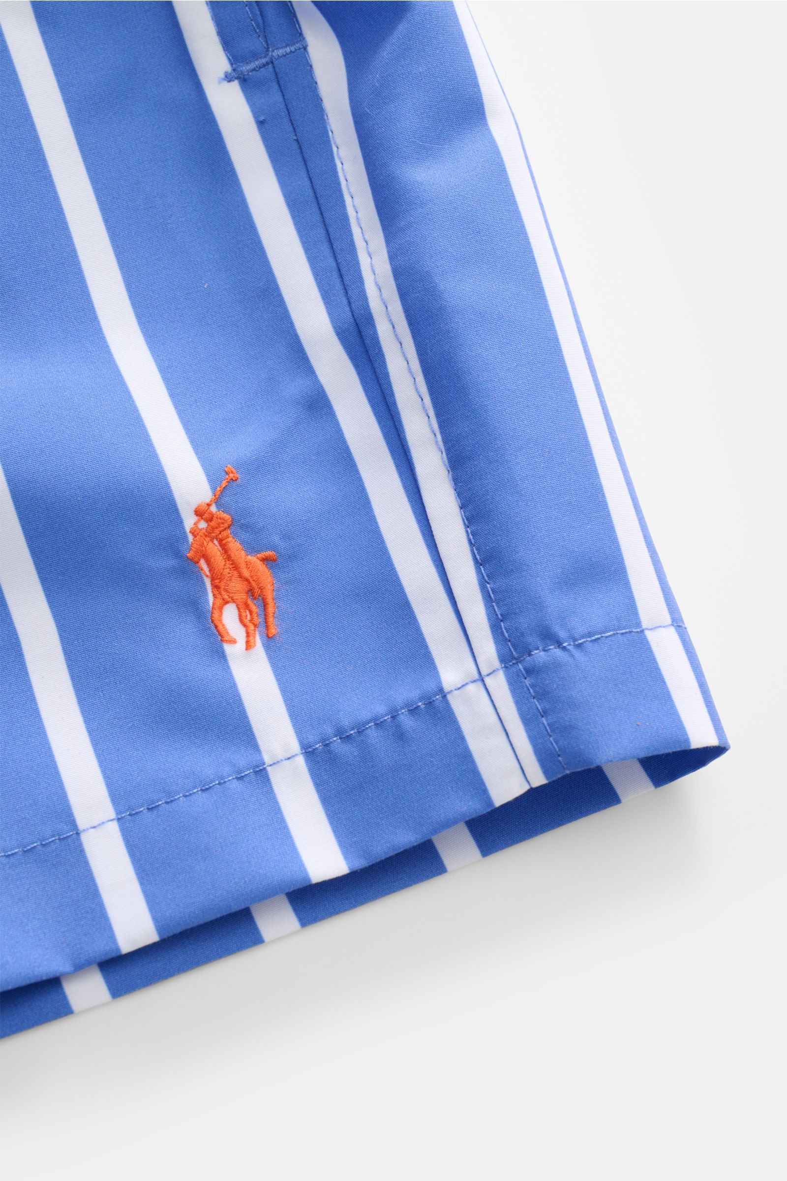 Close-up side view of Polo Ralph Lauren Swim shorts 'Traveler' blue/white striped showing orange logo stitching on high-quality microfibre fabric.

Stylish confidence for your travels: These POLO RALPH LAUREN swim shorts are the perfect companion for y
