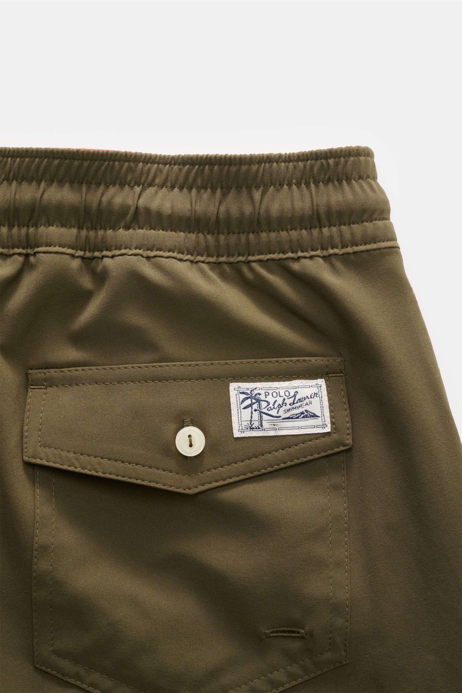 Nahaufnahme der Polo Ralph Lauren Badeshorts 'Traveler' oliv von hinten oben, elastischer Bund, geknöpfte Gesäßtasche mit Logo.