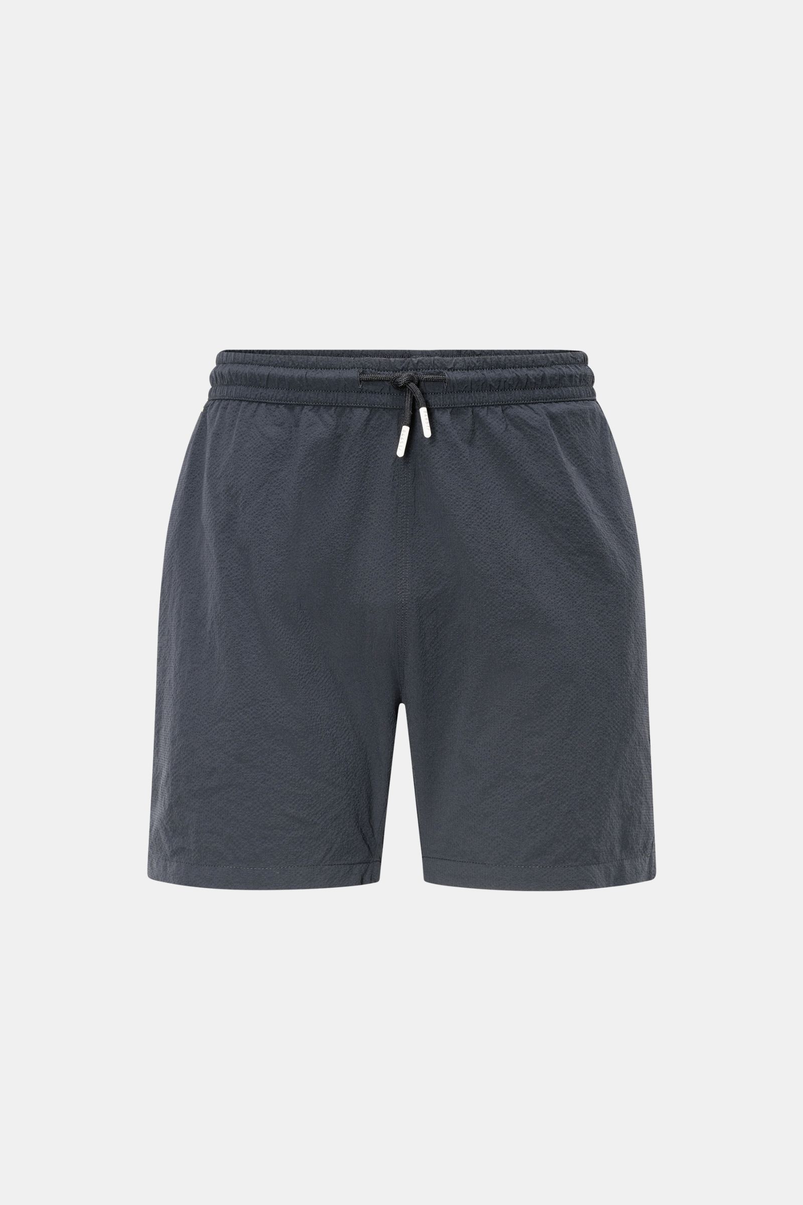 Frontale Nahaufnahme der 04651/ A trip in a bag Badeshorts 'Mono Seersucker' navy aus hochwertiger Microfaser mit elastischem Bund, Tunnelzug, Regular Fit, Mesh-Innenfutter, seitlichen Saumschlitzen und Taschen, ideal für Sommerurlaub.