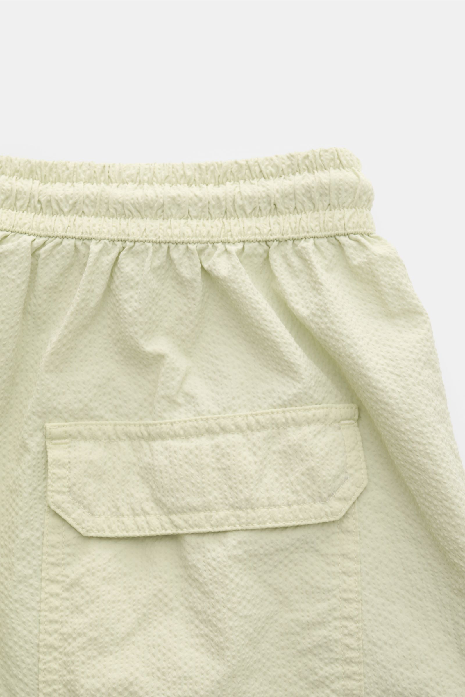 04651/ A trip in a bag Badeshorts 'Mono Seersucker' salbei, Nahaufnahme Rückseite mit elastischem Bund, Tasche und Seersucker-Microfaser.