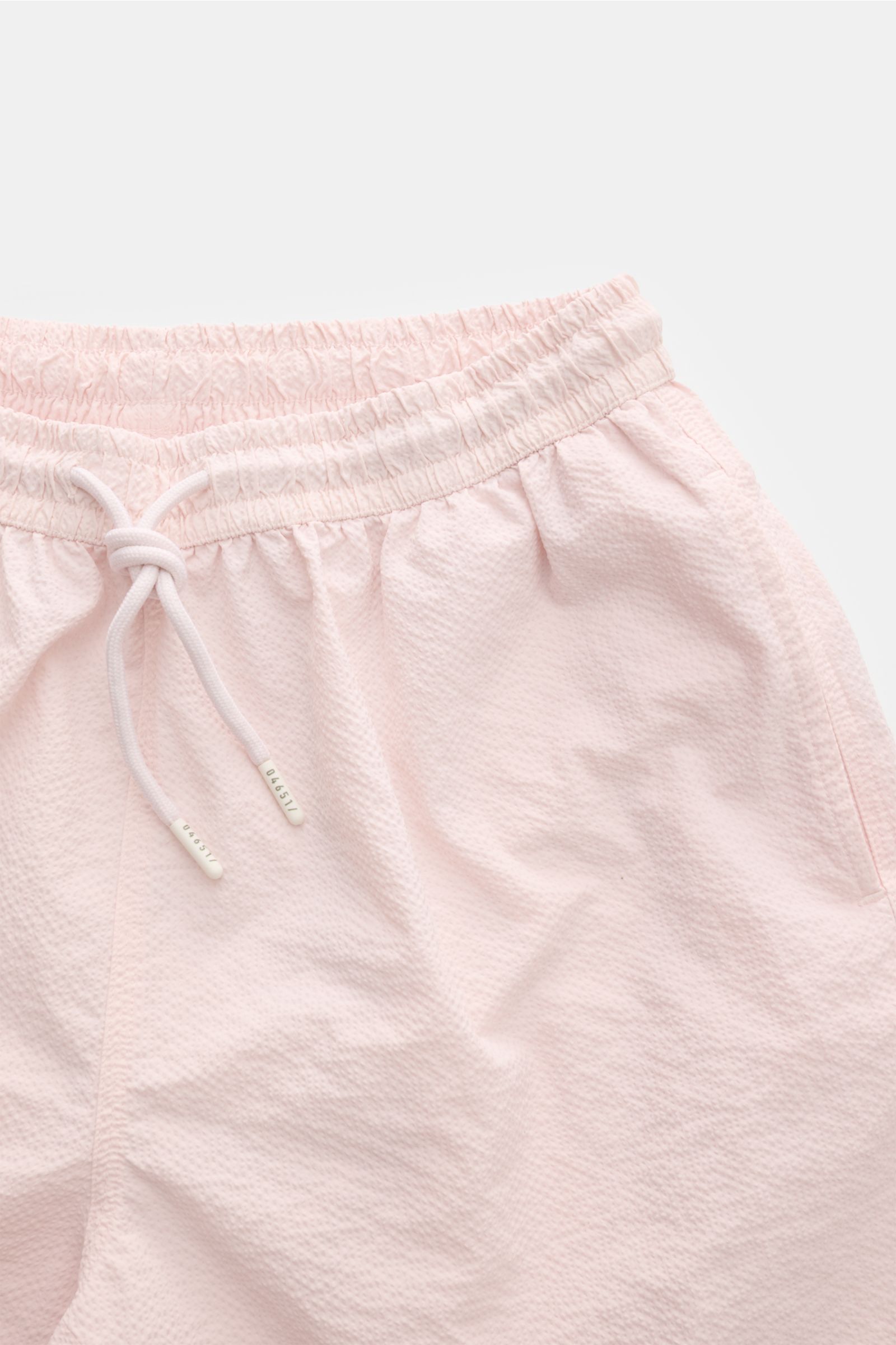 Close-up front view of 04651/ A trip in a bag Swim shorts 'Mono Seersucker' rose in light pink seersucker fabric with elastic waistband and drawstring. 

Perfect for your next summer holiday: With their design in seersucker look, these swim shorts by 0465