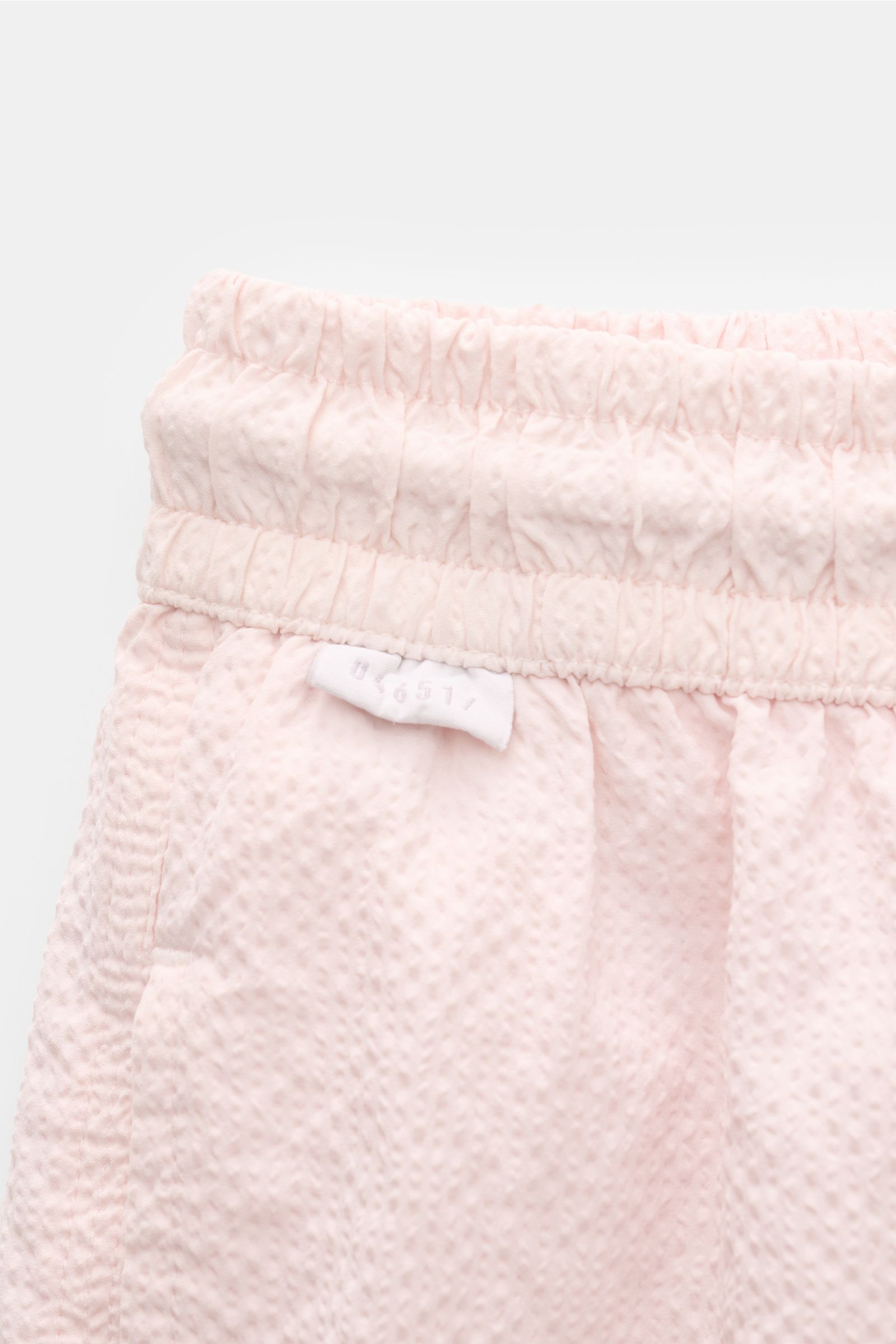 Close-up front view of 04651/ A trip in a bag Swim shorts 'Mono Seersucker' rose in light pink seersucker fabric with elastic waistband.

Perfect for your next summer holiday: With their design in seersucker look, these swim shorts by 04651/ A TRIP IN 