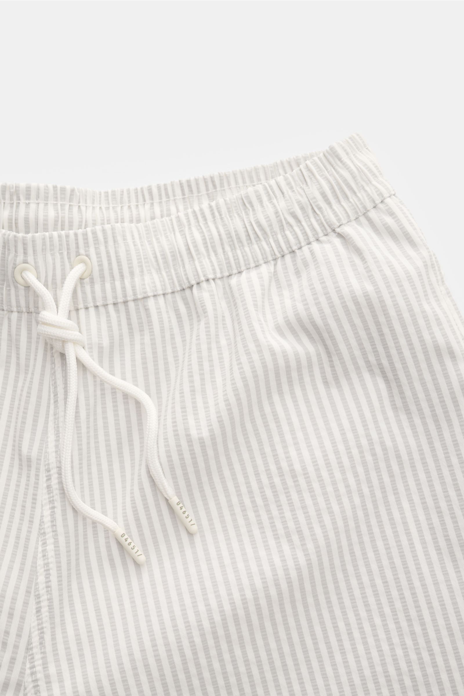 Close-up top view of 04651/ A trip in a bag Swim shorts light grey/white striped with elastic waistband and drawstring.

Perfect for your next summer holiday: With their modern striped pattern, these swim shorts by 04651/ A TRIP IN A BAG are an eye-cat