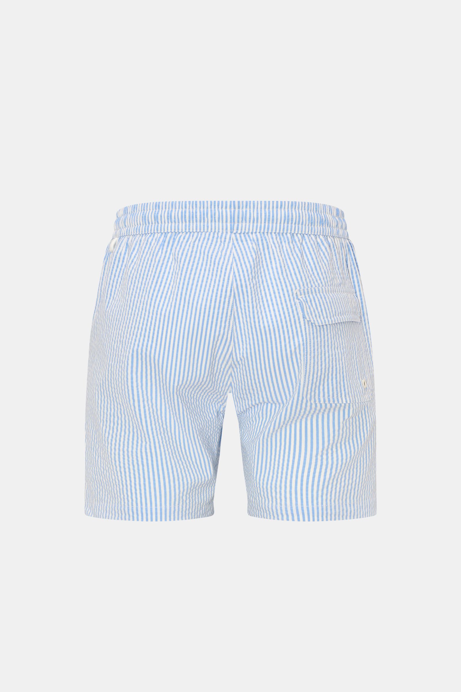 Rear view of 04651/ A trip in a bag Swim shorts blue/white striped with elastic waistband, side pockets, back pocket with flap, and side vents.

Perfect for your next summer holiday: With their modern striped pattern, these swim shorts by 04651/ A TRIP