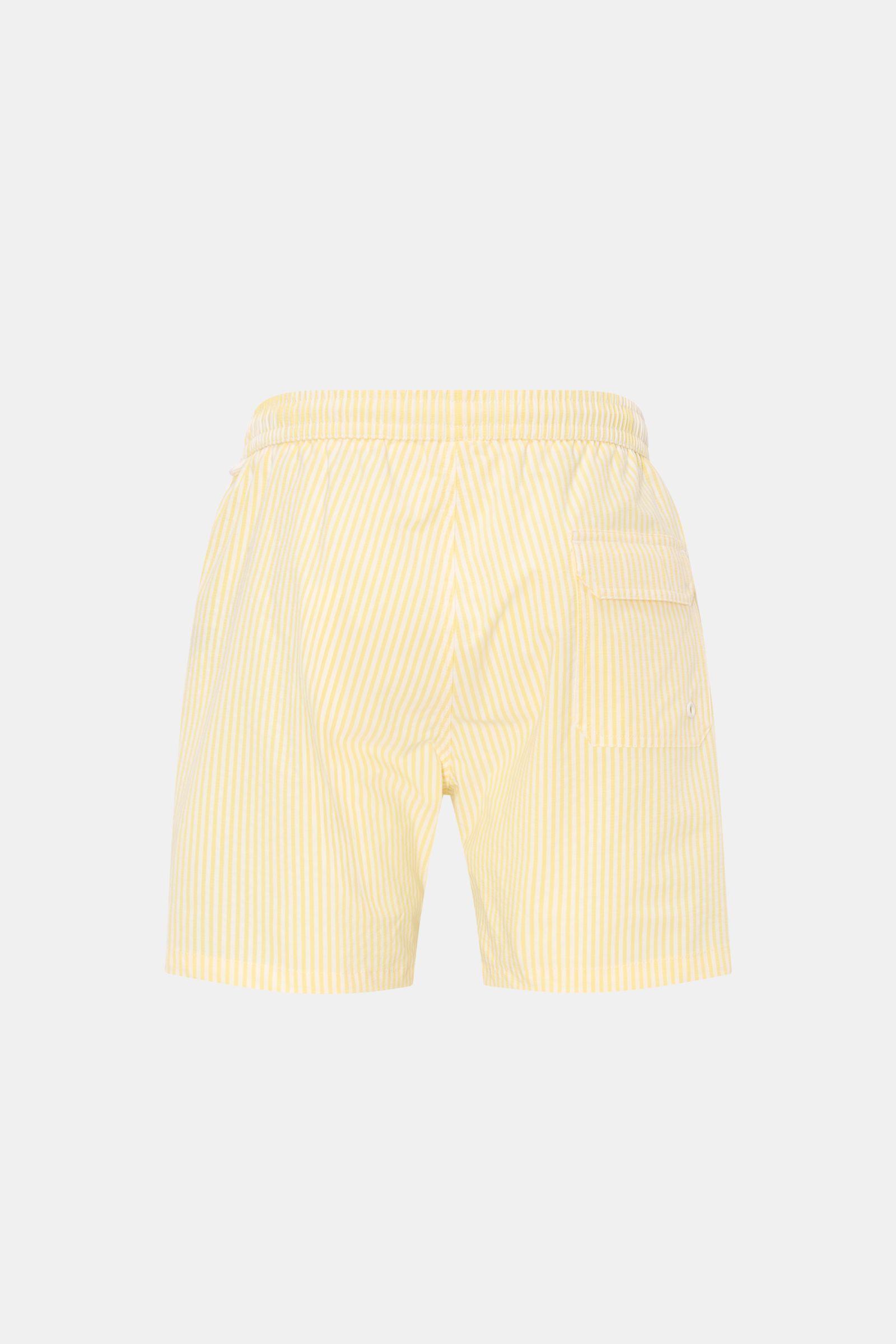 Rear view of 04651/ A trip in a bag Swim shorts pastel yellow/white striped with elastic waistband, back pocket, and side vents.

Description: 
Perfect for your next summer holiday: With their modern striped pattern, these swim shorts by 04651/ A TRIP 