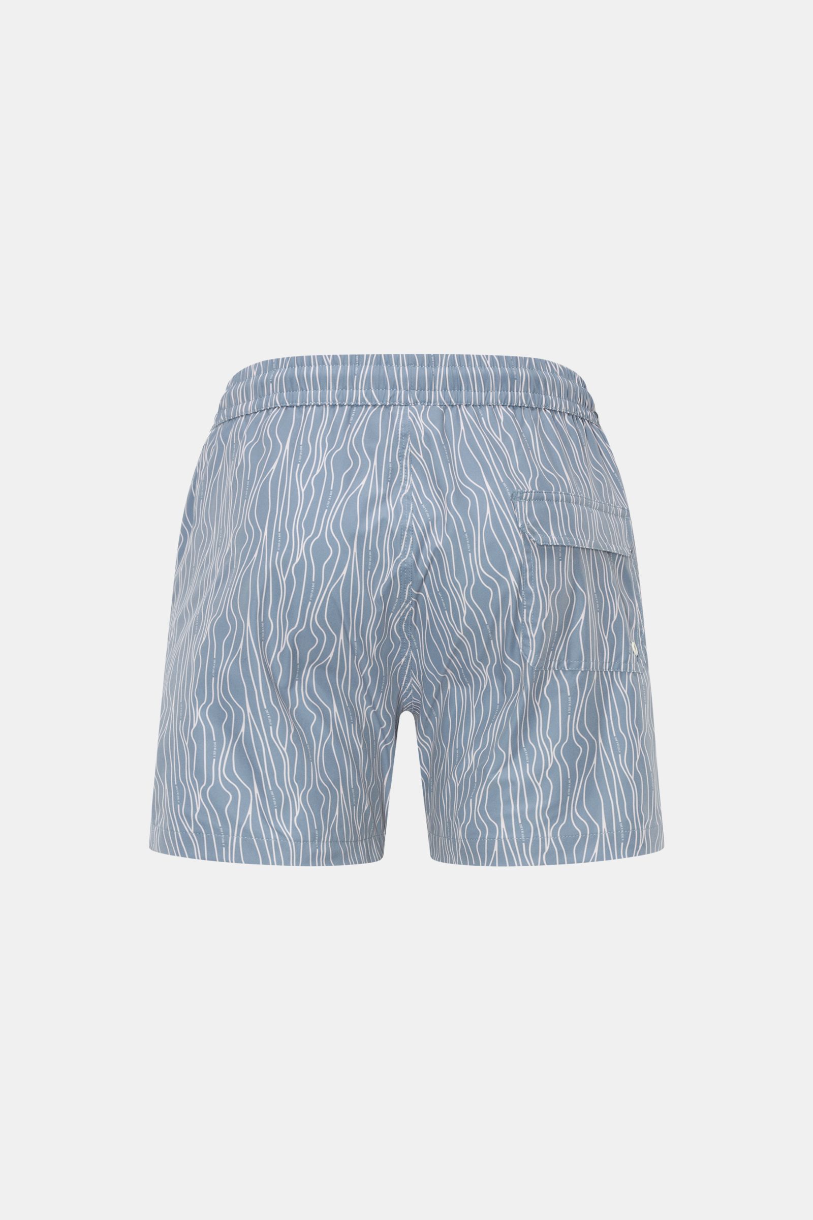 Rear view of 04651/ A trip in a bag Swim shorts 'Superkilen' smoky blue/white patterned with elastic waistband, back pocket, and wavy print.

Description:  
An eye-catching piece for summer: With their all-over print inspired by Copenhagen’s 'Superkile