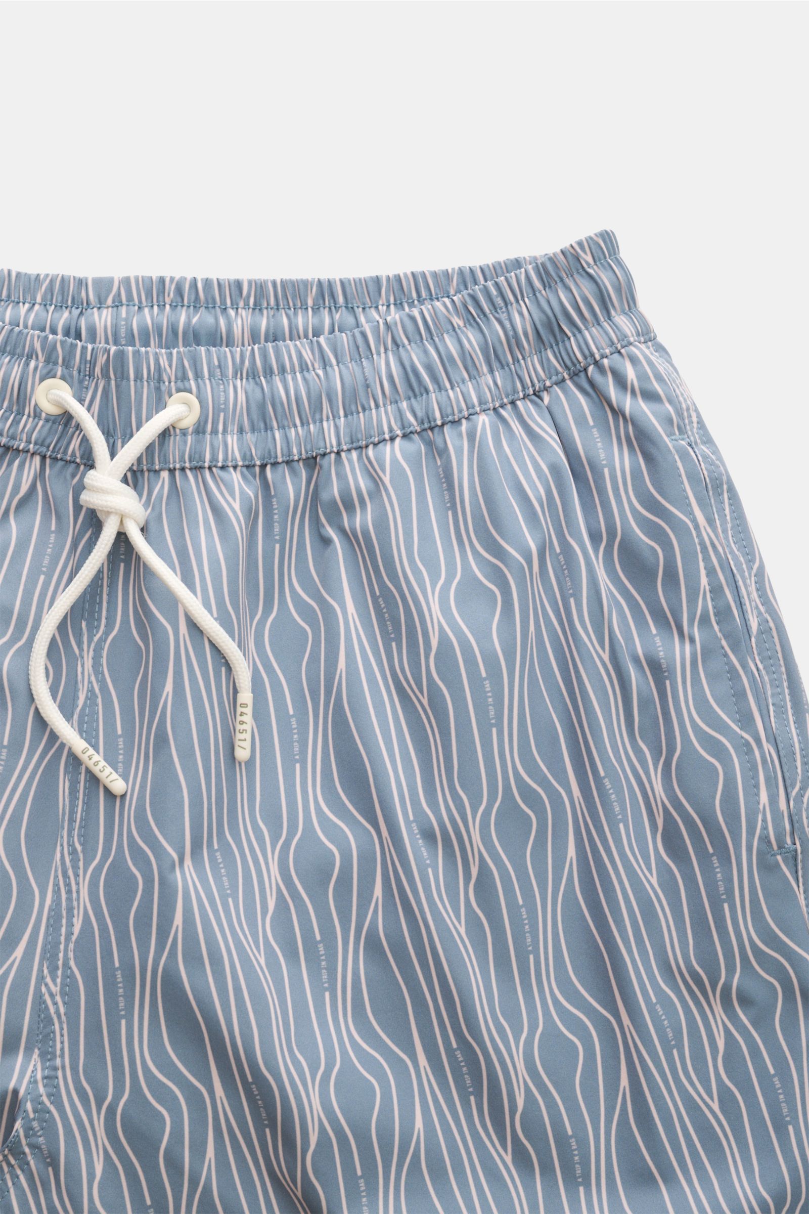 Close-up front view of 04651/ A trip in a bag Swim shorts 'Superkilen' smoky blue/white patterned with elasticated waistband and white drawstring.

An eye-catching piece for summer: With their all-over print inspired by Copenhagen’s 'Superkilen' park, 