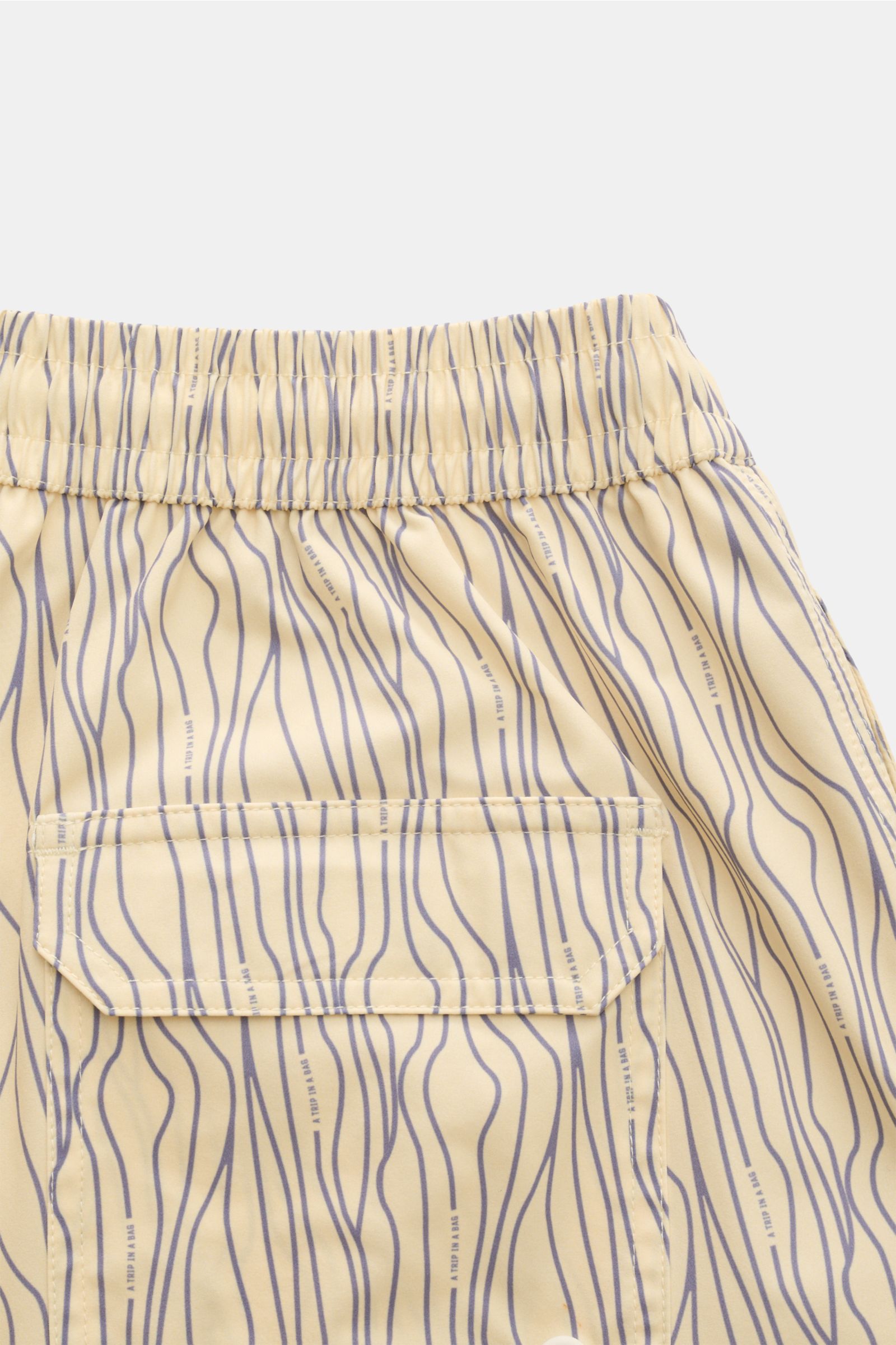 Close-up rear view of 04651/ A trip in a bag Swim shorts 'Superkilen' pastel yellow/lavender patterned, showing elasticated waistband and back pocket.

An eye-catching piece for summer: With their all-over print inspired by Copenhagen’s 'Superkilen' pa