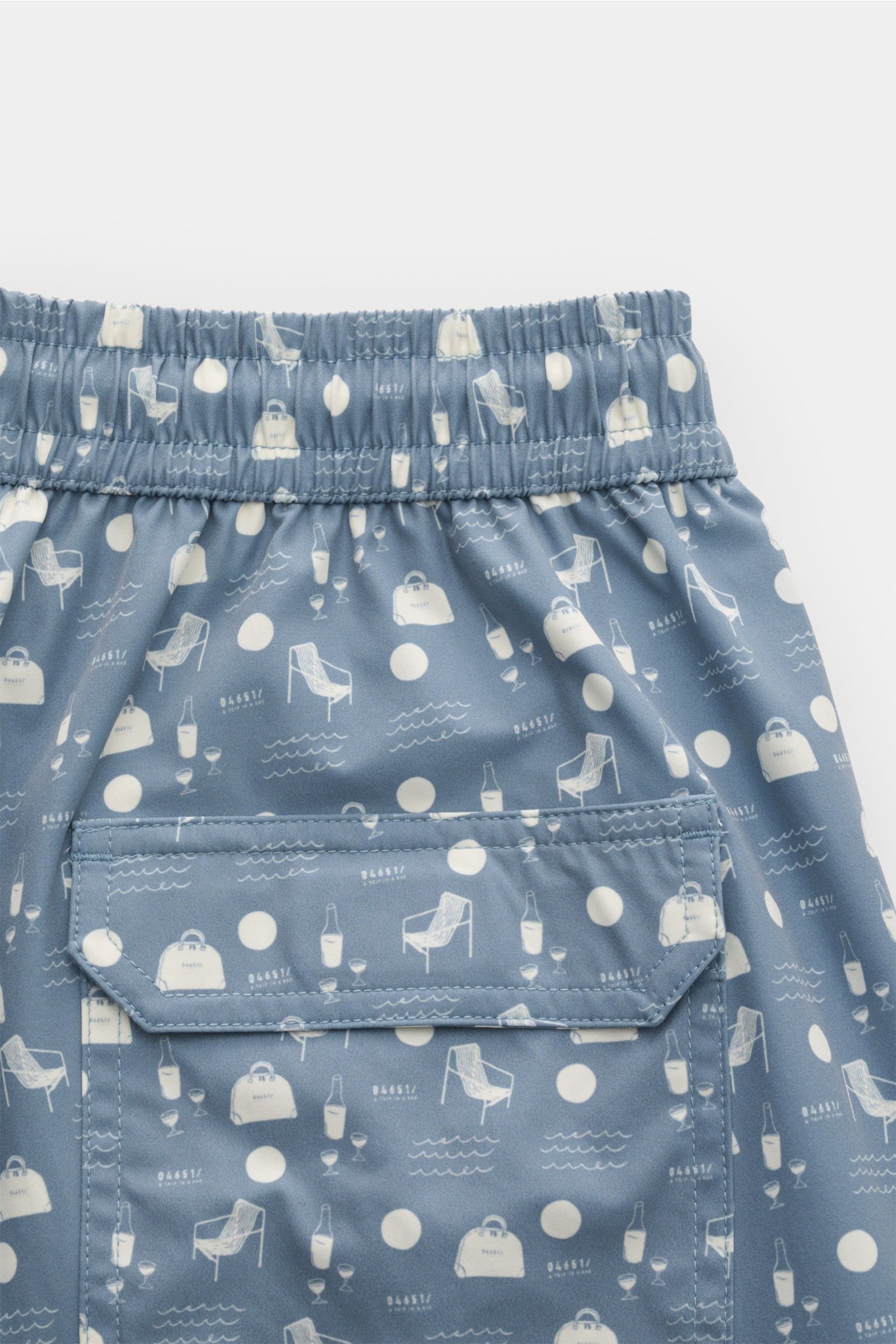 04651/ A trip in a bag Badeshorts 'Seaside' rauchblau/creme gemustert, Detailansicht Rückseite mit elastischem Bund, Gesäßtasche mit Klettverschluss, Regular Fit, Microfaser, leichter Griff, Saumschlitze, Mesh-Innenfutter.