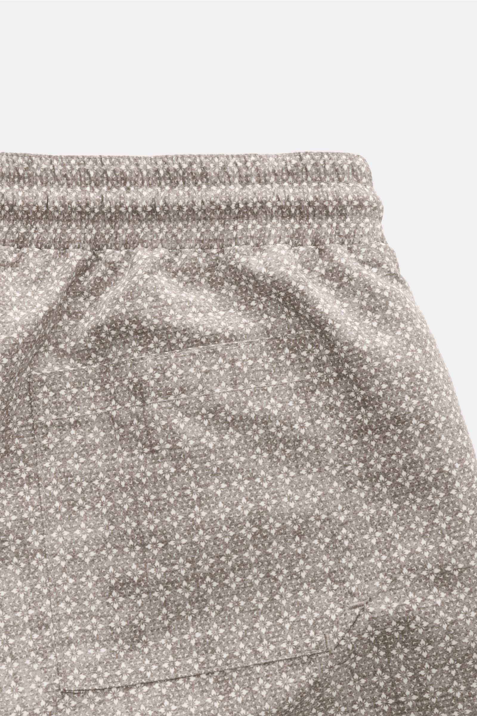Close-up rear view of Brunello Cucinelli Badeshorts oliv/creme gemustert with floral pattern, elastic waistband, and back pocket.

Luxuriös entspannen: Mit ihrem floralen Muster sowie dezenten Logo-Stitching werden die Badeshorts von BRUNELLO CUCINELLI