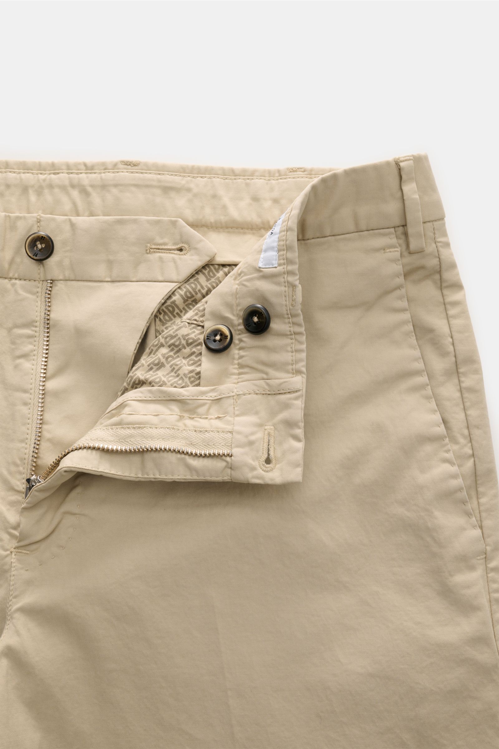 PT Torino Bermudas beige aus twill reiner Baumwolle, griffig, leicht elastisch, garment dyed, Regular Fit, Reißverschluss, Bundknöpfe, französische Taschen, Uhrentasche, paspelierte Gesäßtaschen, Detailansicht von vorne oben.