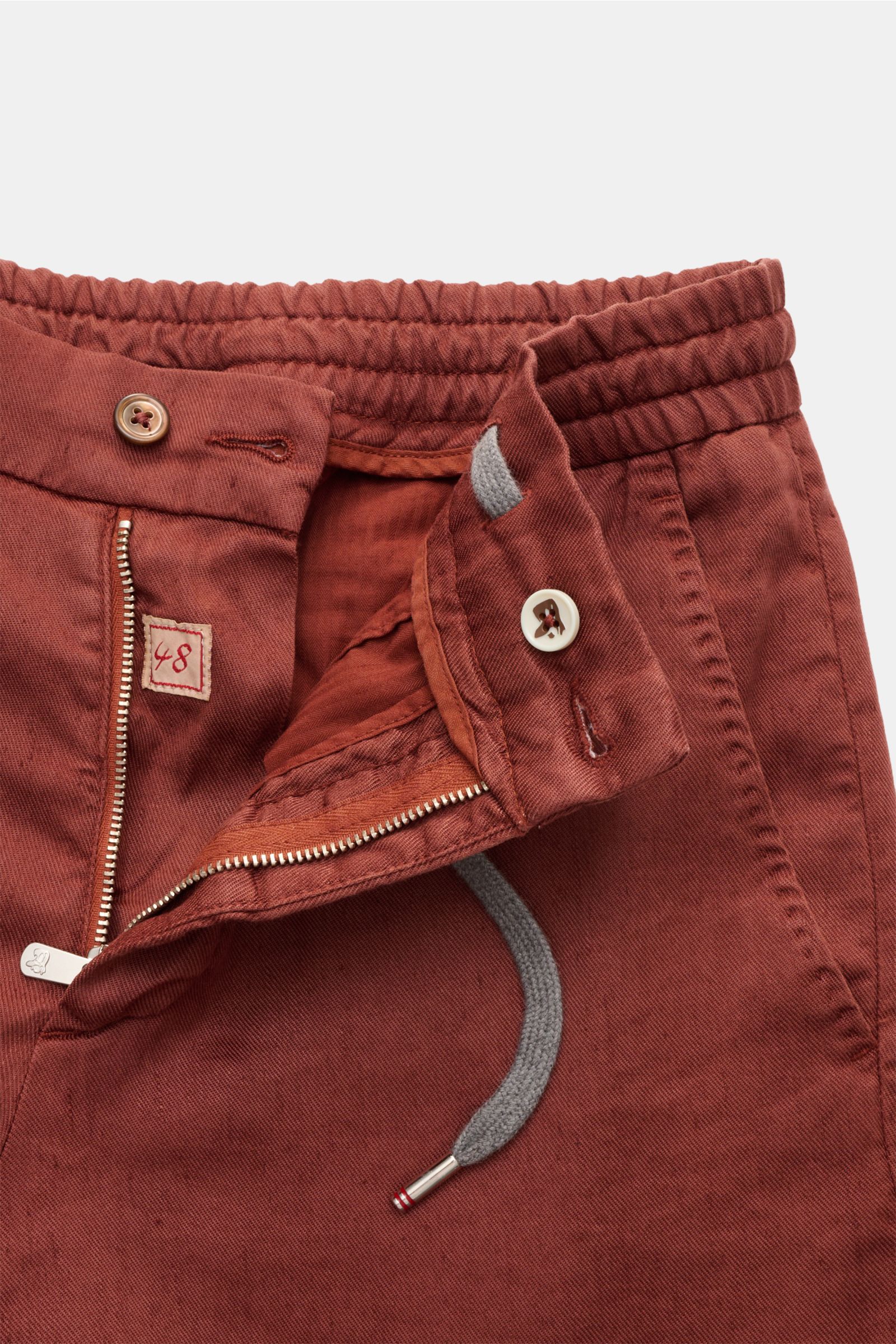 Marco Pescarolo Bermudas 'Cenito' rotbraun in Nahaufnahme von oben, elastischer Bund, Tunnelzug, Reißverschluss und Knopf sichtbar.