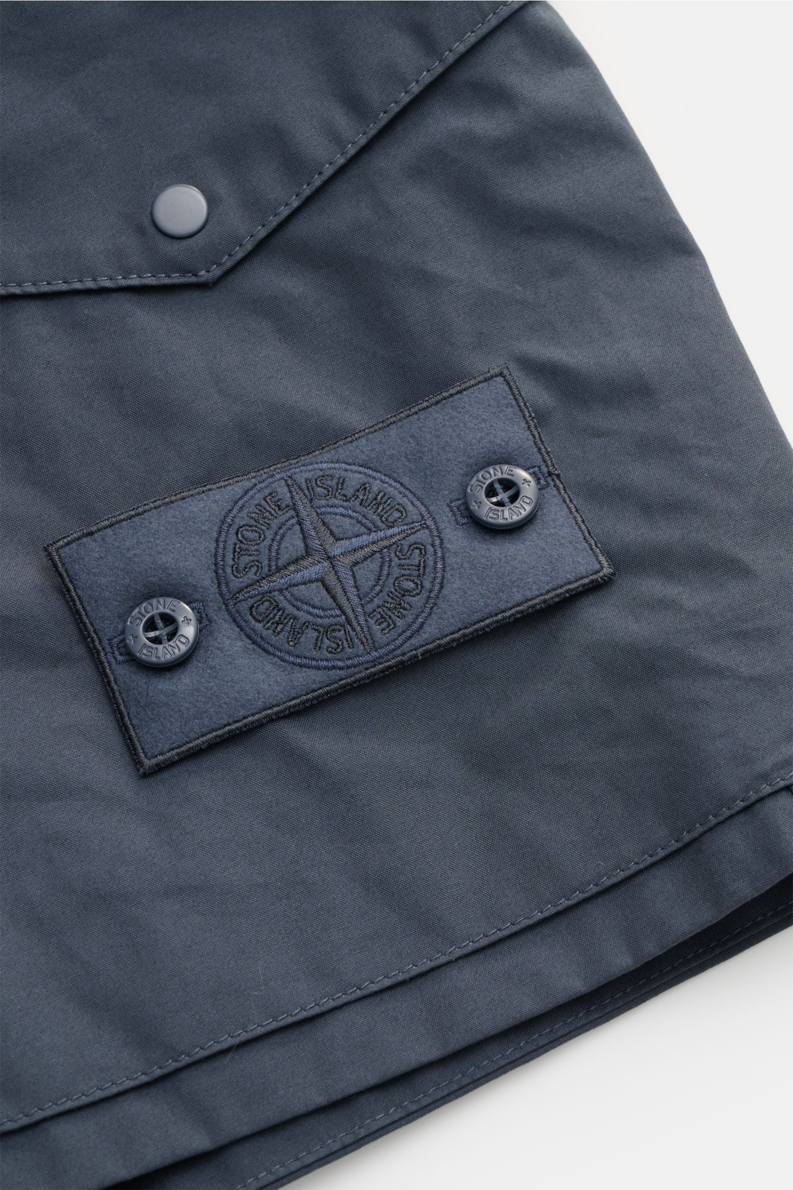 Alt tag (125 characters max): Close-up front view of Stone Island Shorts 'Ghost' grey-blue showing signature compass badge and button details.

Description:  
Modern utility design: These STONE ISLAND shorts from the 'Ghost' Capsule Collection are time