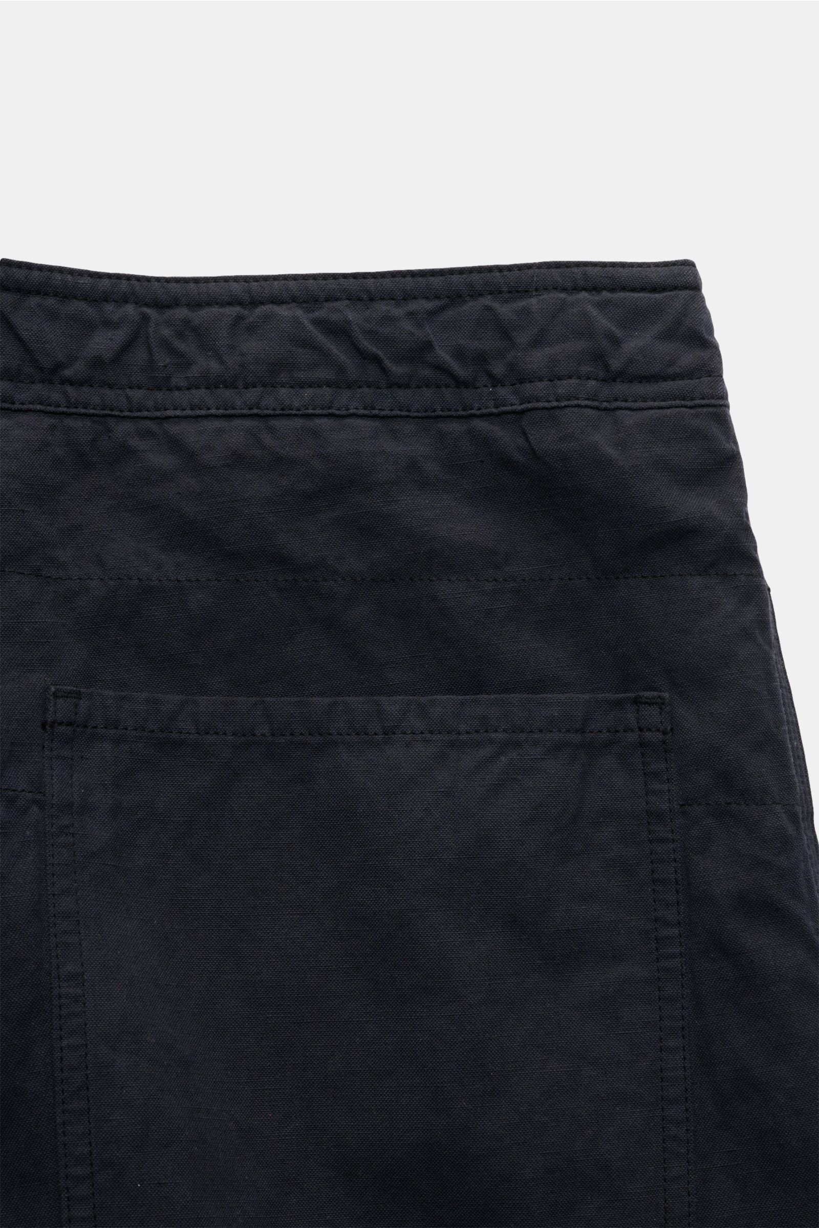 Stone Island Shorts 'Ghost Piece' navy shown from a close-up back view, made of robust cotton-linen canvas with tonal compass badge, garment dyed, regular fit, zipper and button, French pockets, and patch back pockets; monochrome summer piece from the Gho