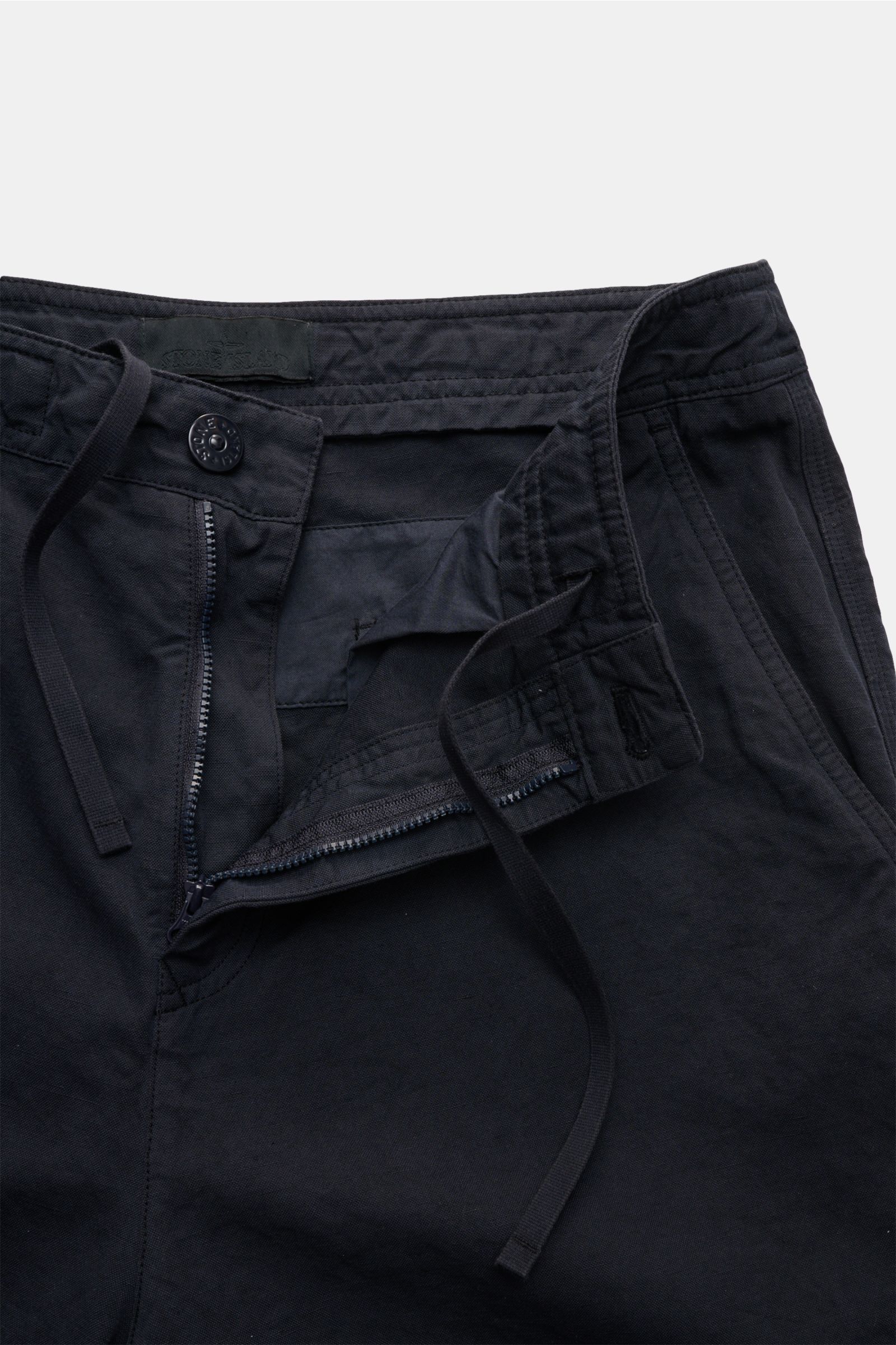 Close-up front view of Stone Island Shorts 'Ghost Piece' navy, made from cotton-linen canvas with zipper, button, and drawstring closure.

Monochromes Sommer-Piece: die komfortablen Shorts von STONE ISLAND aus der 'Ghost Collection' wurden aus robustem Ba