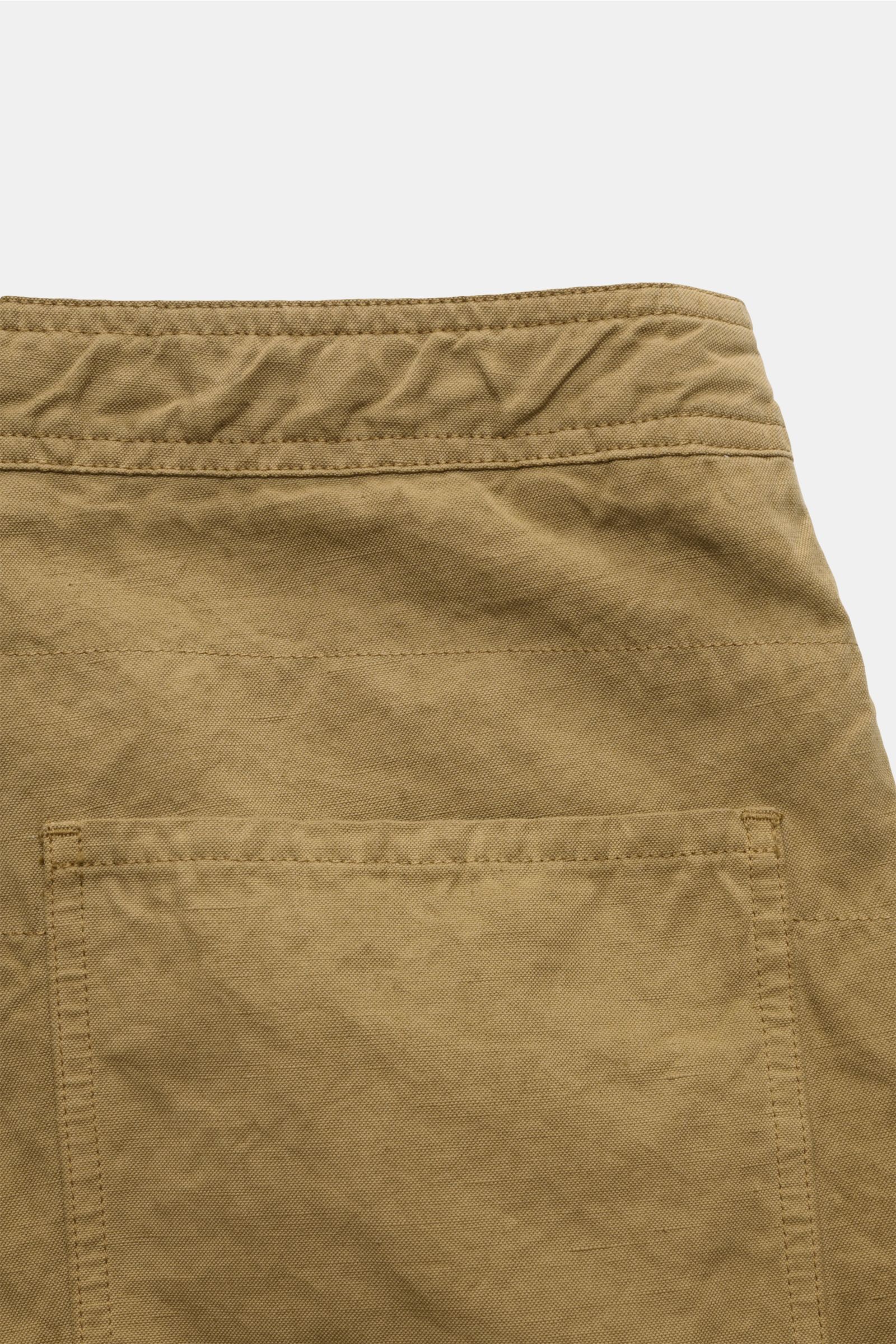 Stone Island Shorts 'Ghost Piece' khaki shown from a close-up rear angle, highlighting the robust cotton-linen canvas, garment-dyed fabric, tonal compass badge, regular fit with zipper and button closure, French pockets, and patch back pockets. Monochrome
