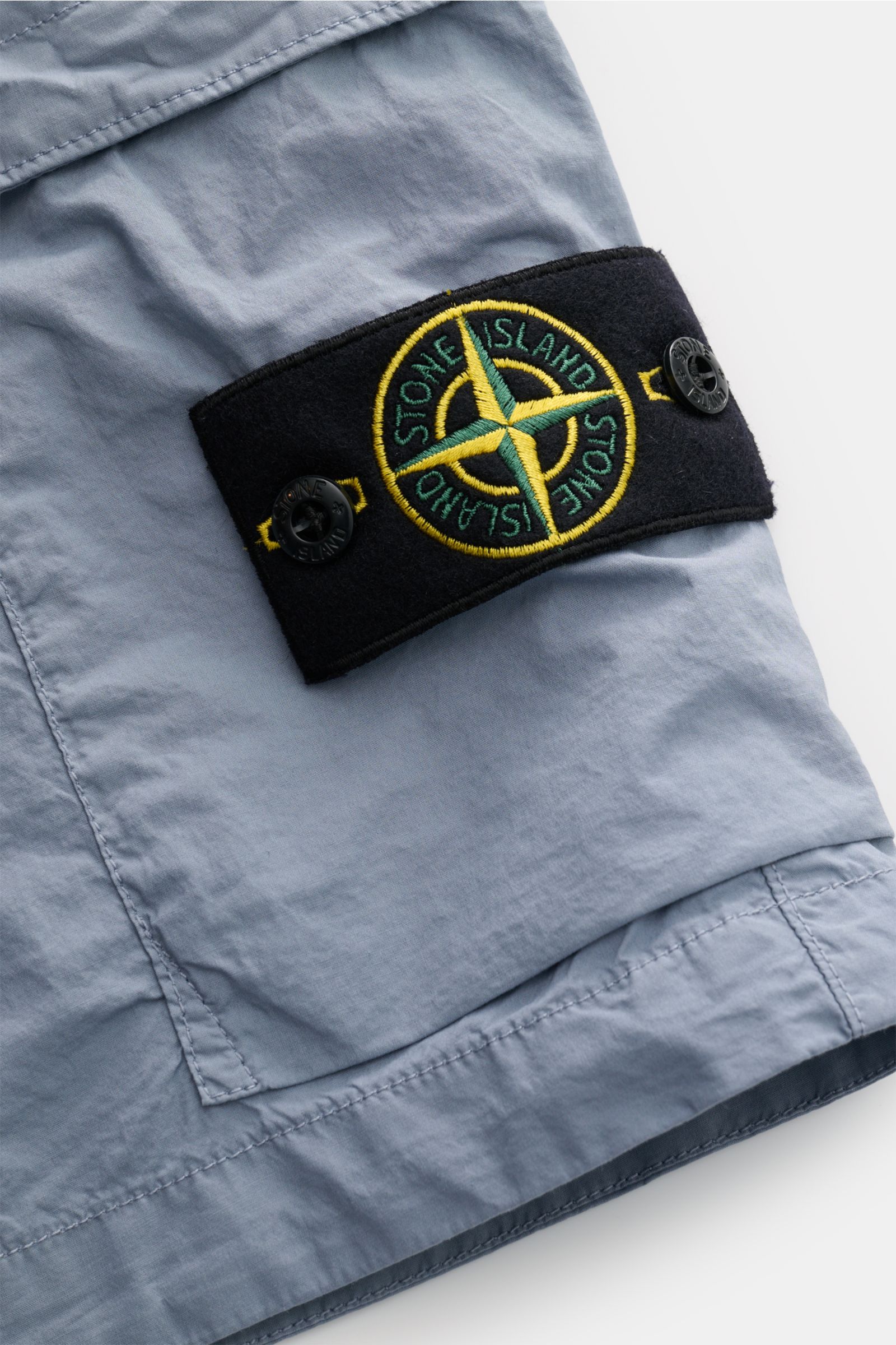 Stone Island Cargo-Shorts rauchblau, Detailaufnahme der Cargotasche mit Kompass-Badge aus leicht elastischer Baumwolle, weicher Griff.