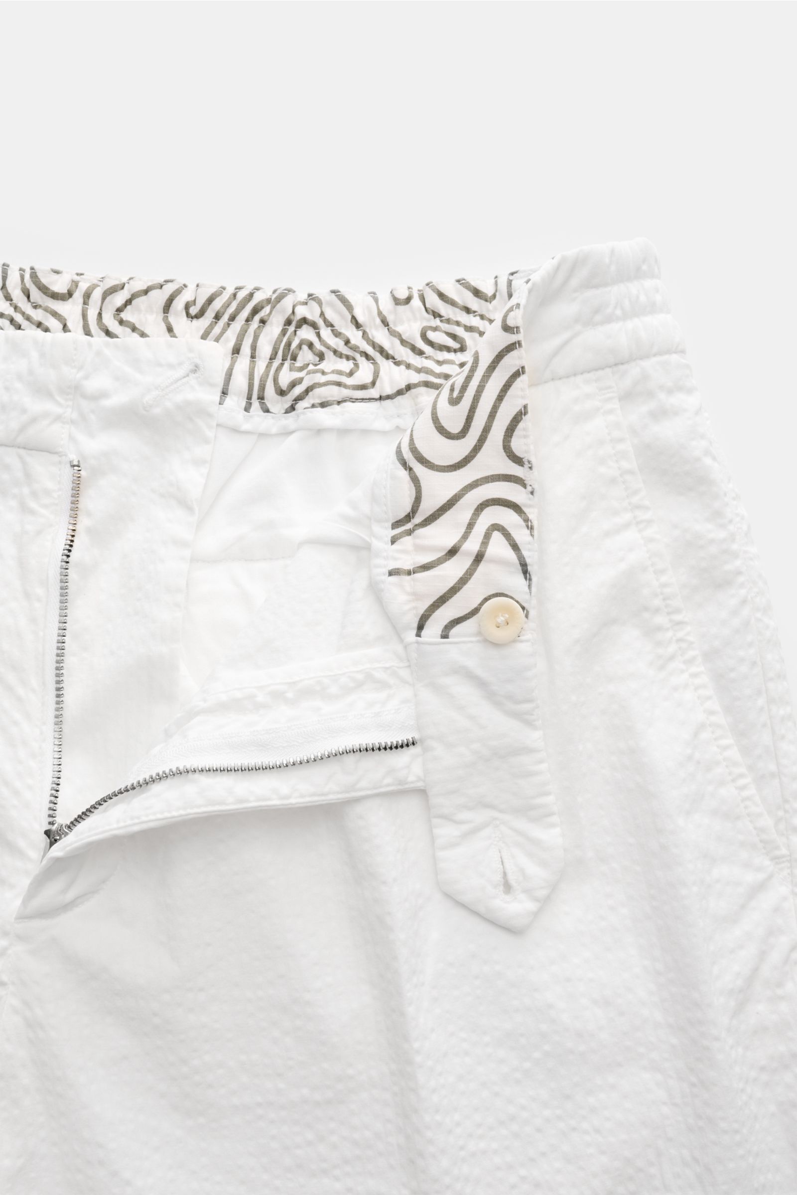 04651/ A trip in a bag Badeshorts 'Plain Swim' off-white, Nahaufnahme der geöffneten Hose mit Tunnelzug, schnelltrocknender Microfaser, Kontrast-Stitching und Mesh-Innenfutter.