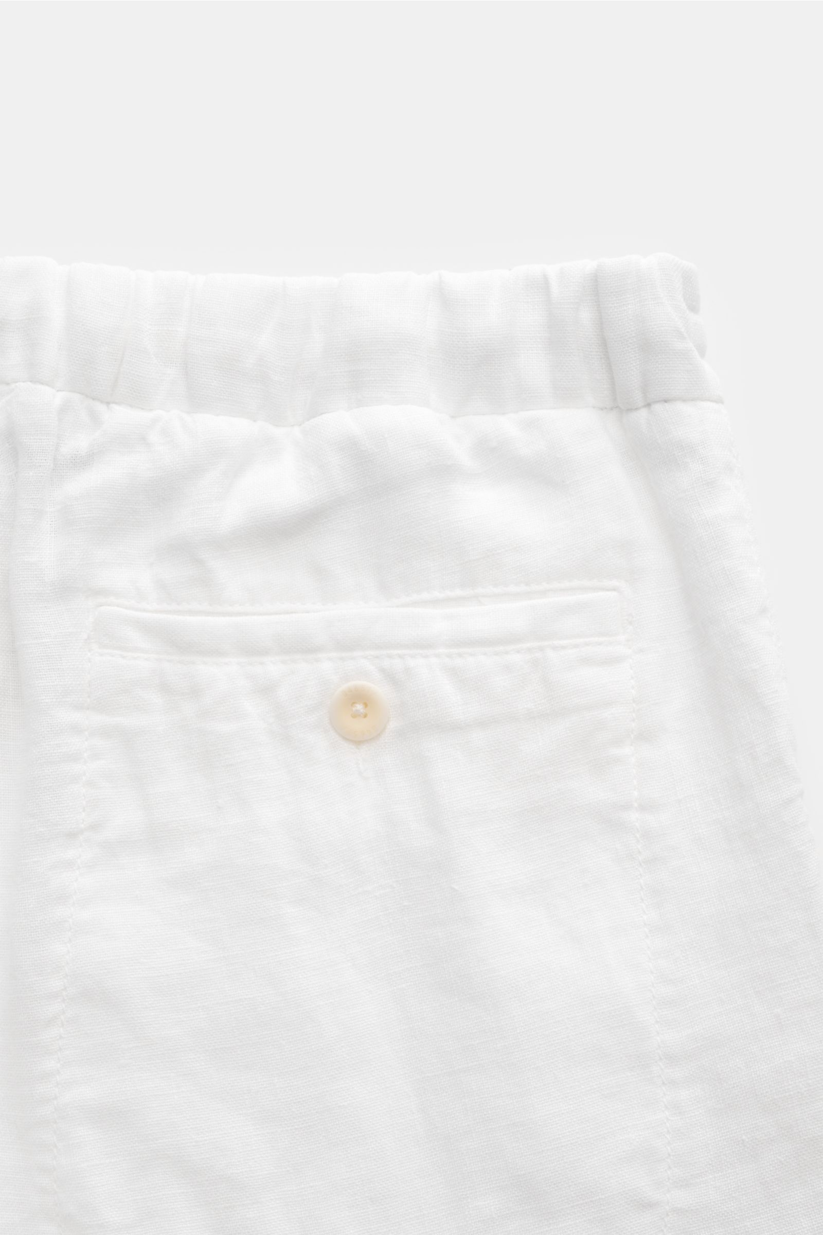 Close-up rear view of 04651/ A trip in a bag Linen bermudas 'Linen Bermuda' white, showing elasticated waistband, back pocket with button, and linen texture.

Description: These airy Bermudas by 04651/ A TRIP IN A BAG are a must-have for your next beach h