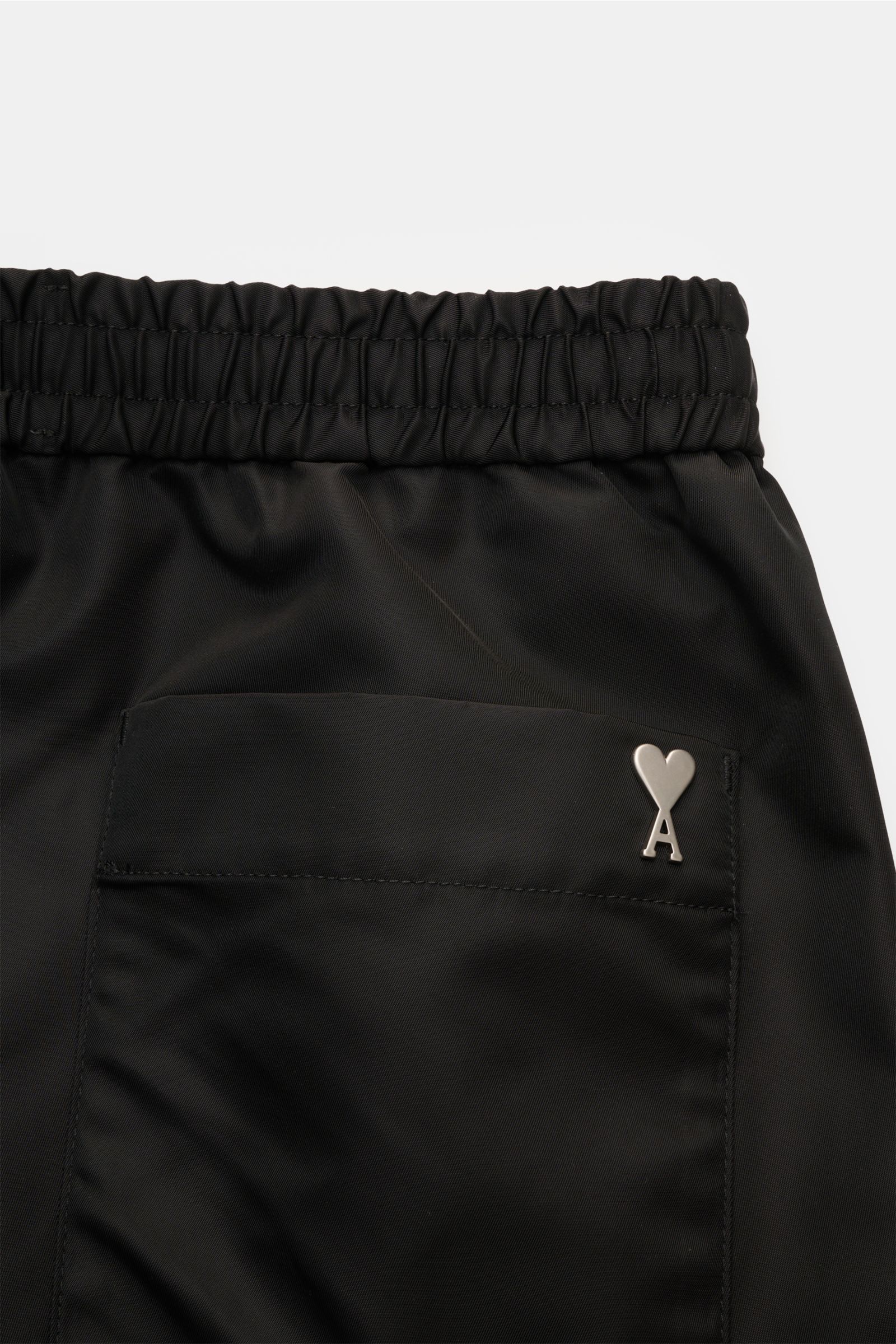 Ami Paris Shorts schwarz, Detailaufnahme der Rückseite mit elastischem Bund, aufgesetzter Gesäßtasche und Metall-Logo, Popeline Nylon.
