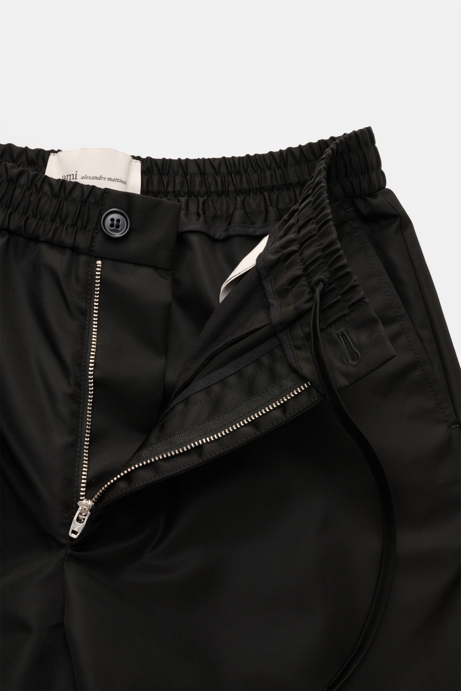 Ami Paris Shorts schwarz mit elastischem Bund, Reißverschluss, Bundknopf und französischen Taschen, Nahaufnahme von vorne.