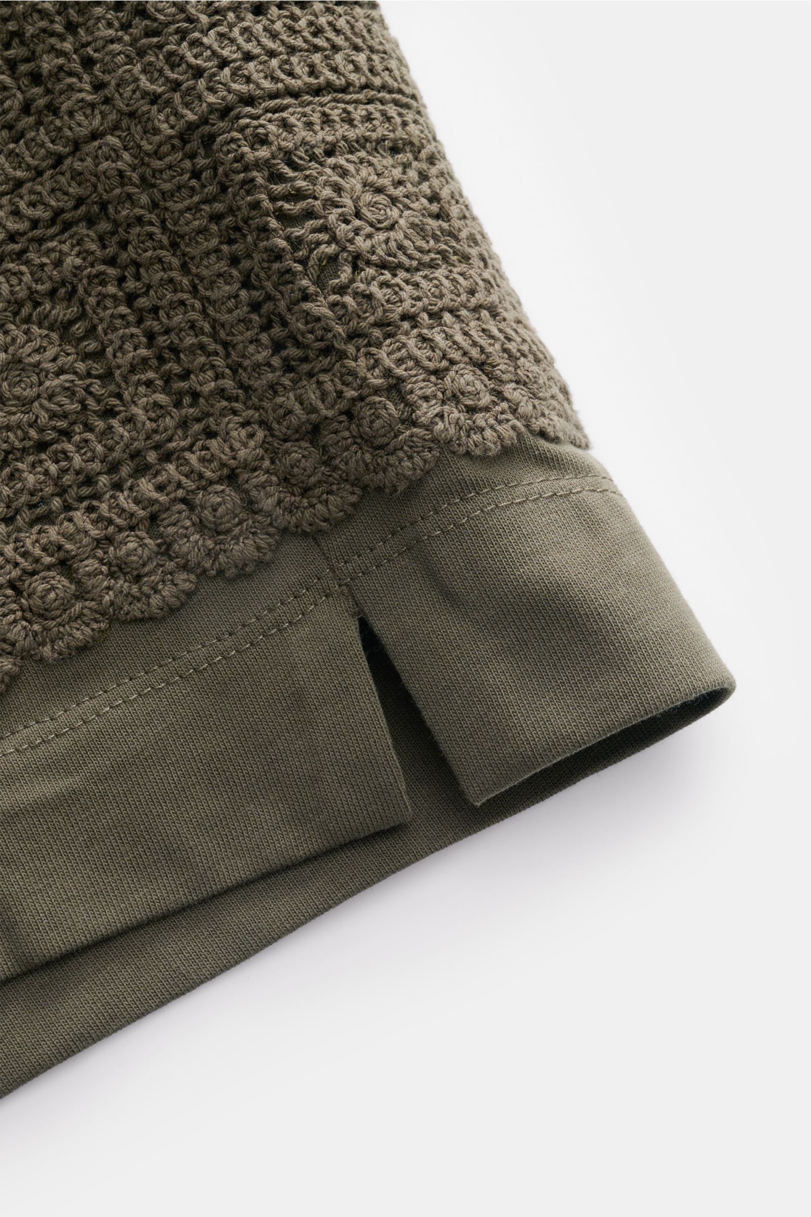 Nahaufnahme der aufgesetzten Häkel-Tasche und Saum der Ché Sweat-Shorts 'Inigo' dark olive aus reiner Baumwolle, weicher Griff.