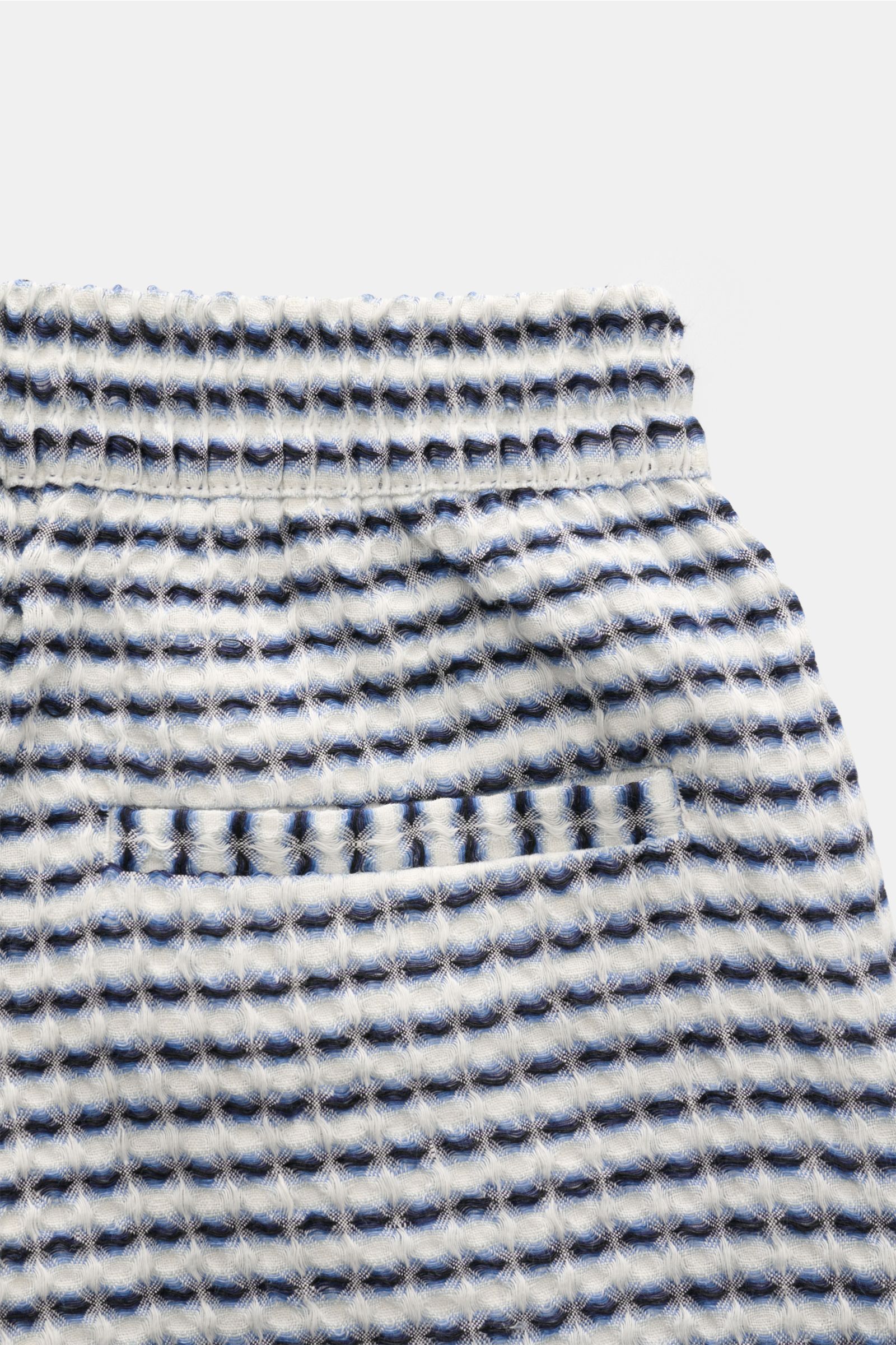 Nahe Aufnahme der elastischen Bundpartie der Ché Shorts 'Riita' blau/weiß gemustert aus grobem, luftigem Leinen-Waffelpiqué.