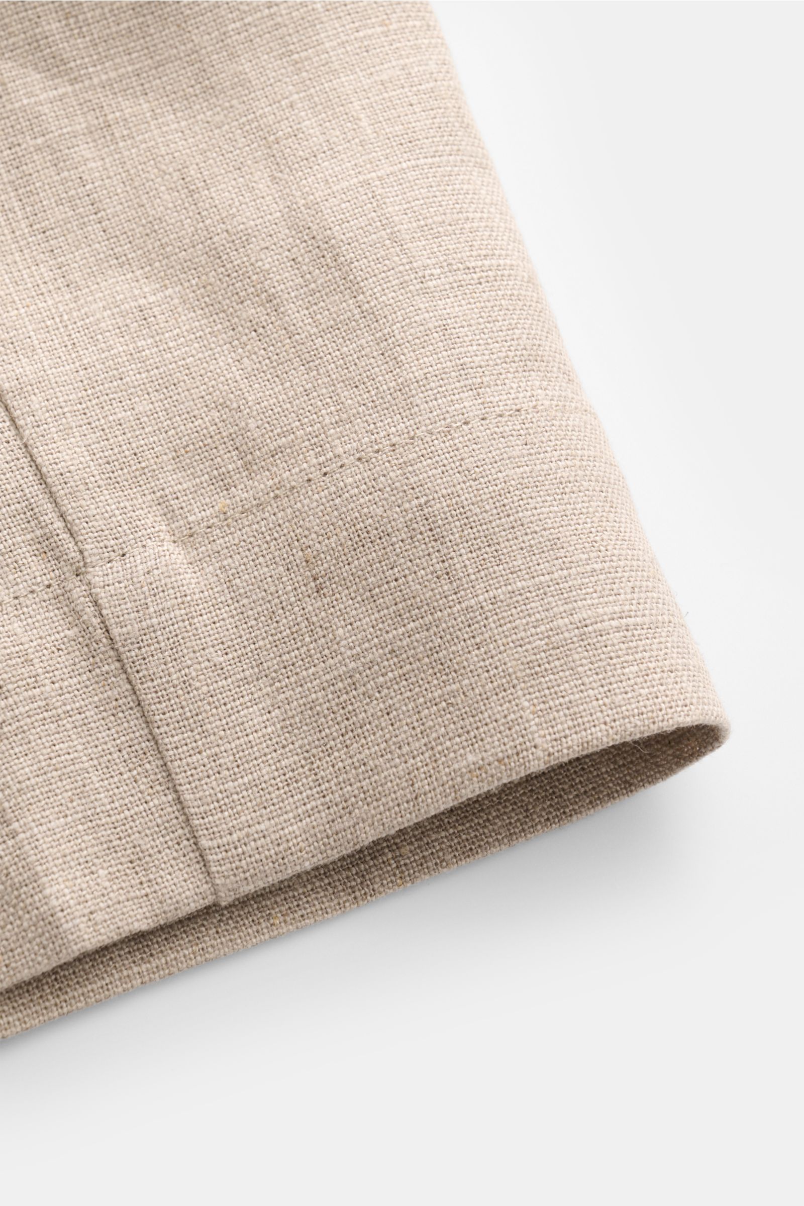 Nahaufnahme der Ché Leinenshorts 'Nevis' beige, fotografiert von schräg oben, zeigt die strukturierte Leinenoberfläche und feine Naht.