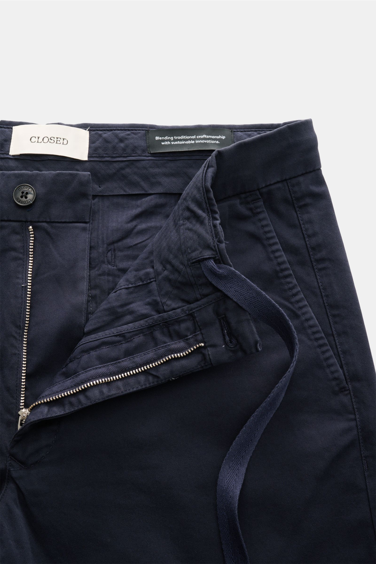 Nahaufnahme der geöffneten Closed Shorts navy aus leicht elastischem Baumwoll-Twill, Regular Fit mit Reißverschluss, Bundknopf und Tunnelzug.