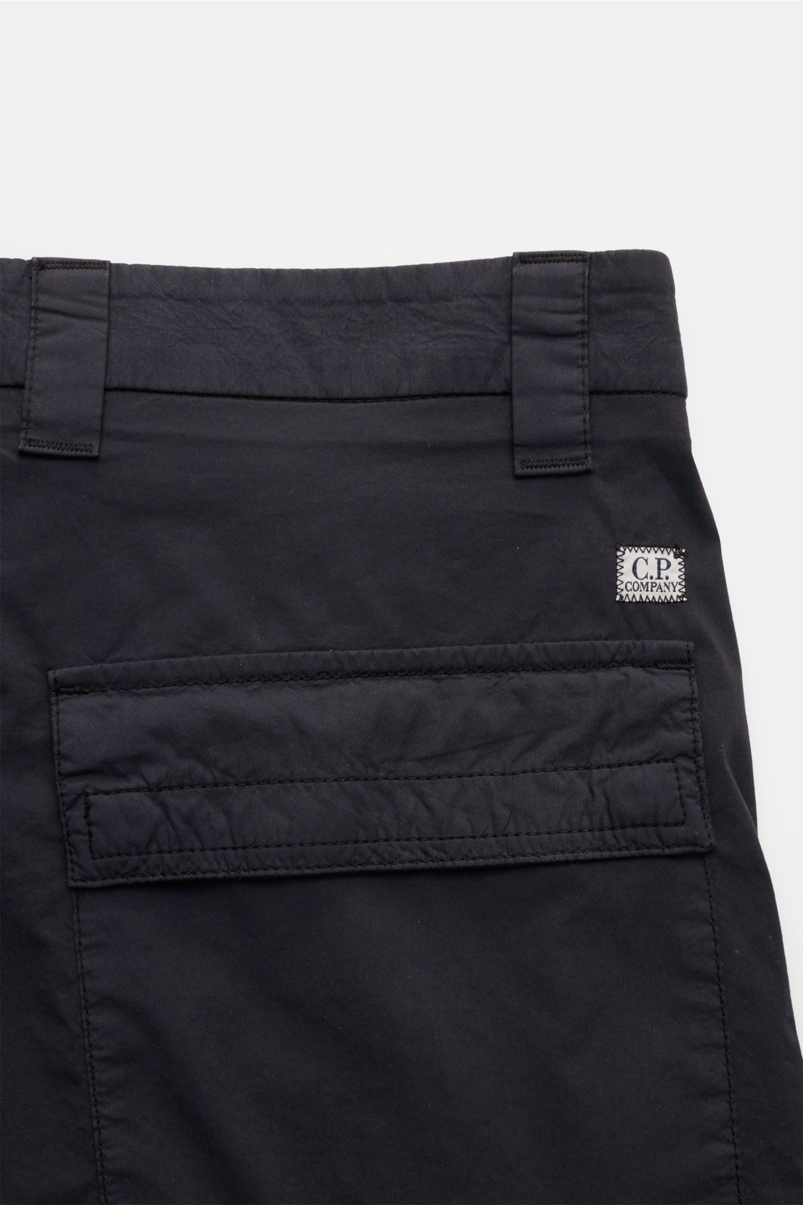 C.P. Company Cargo-Bermudas navy, Detailaufnahme von hinten oben, Utility-Ästhetik, Baumwolle-Microfaser, Cargo- und Gesäßtasche mit Patte, Label-Linsendetail.