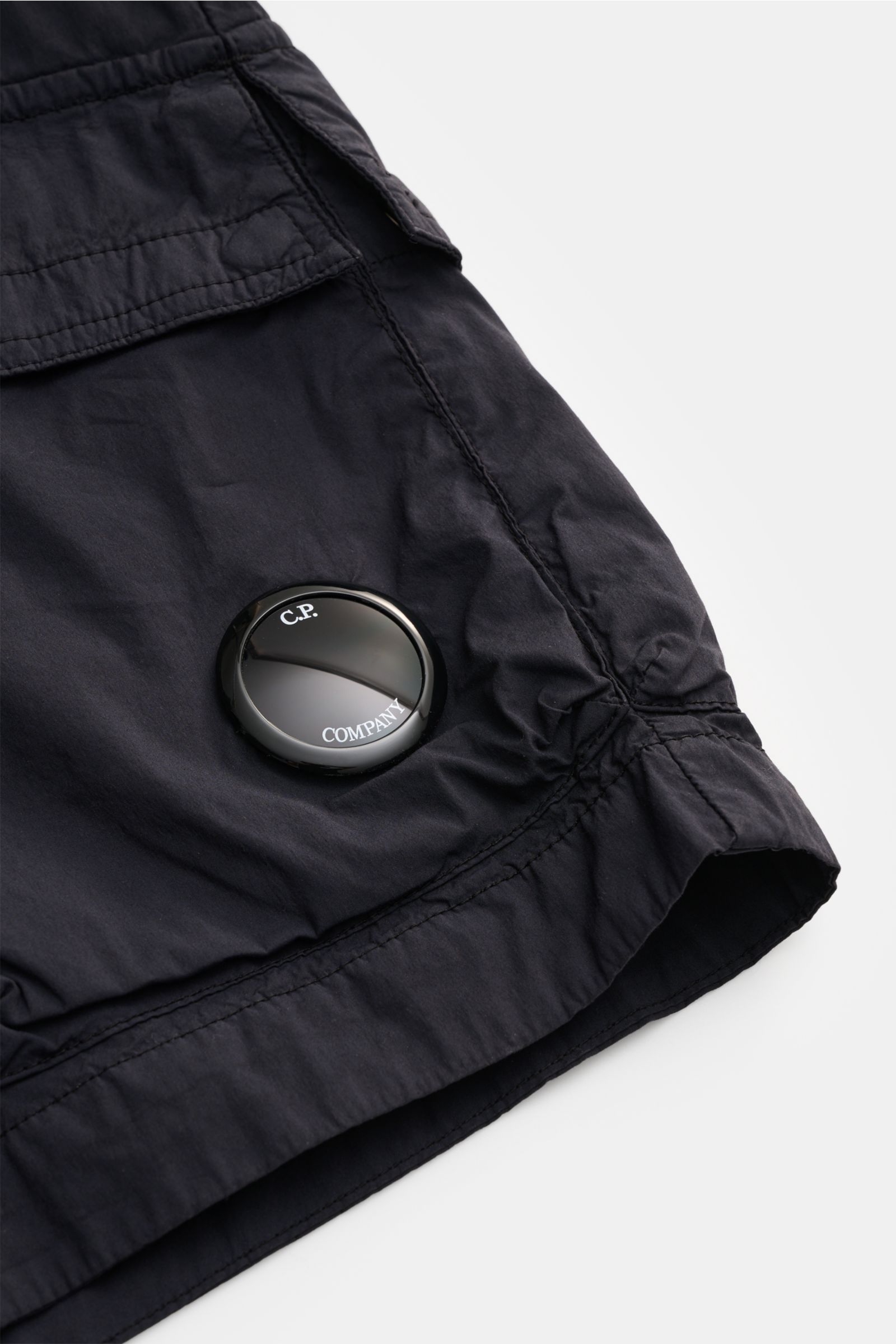 Close-up side view of C.P. Company Cargo-Bermudas navy showing cargo pocket, soft cotton-microfiber fabric, and lens detail.

Utility-Ästhetik für den Sommer: Diese Cargo-Bermudas von C.P. COMPANY kombiniert funktionale Elemente mit entspanntem Fit - p