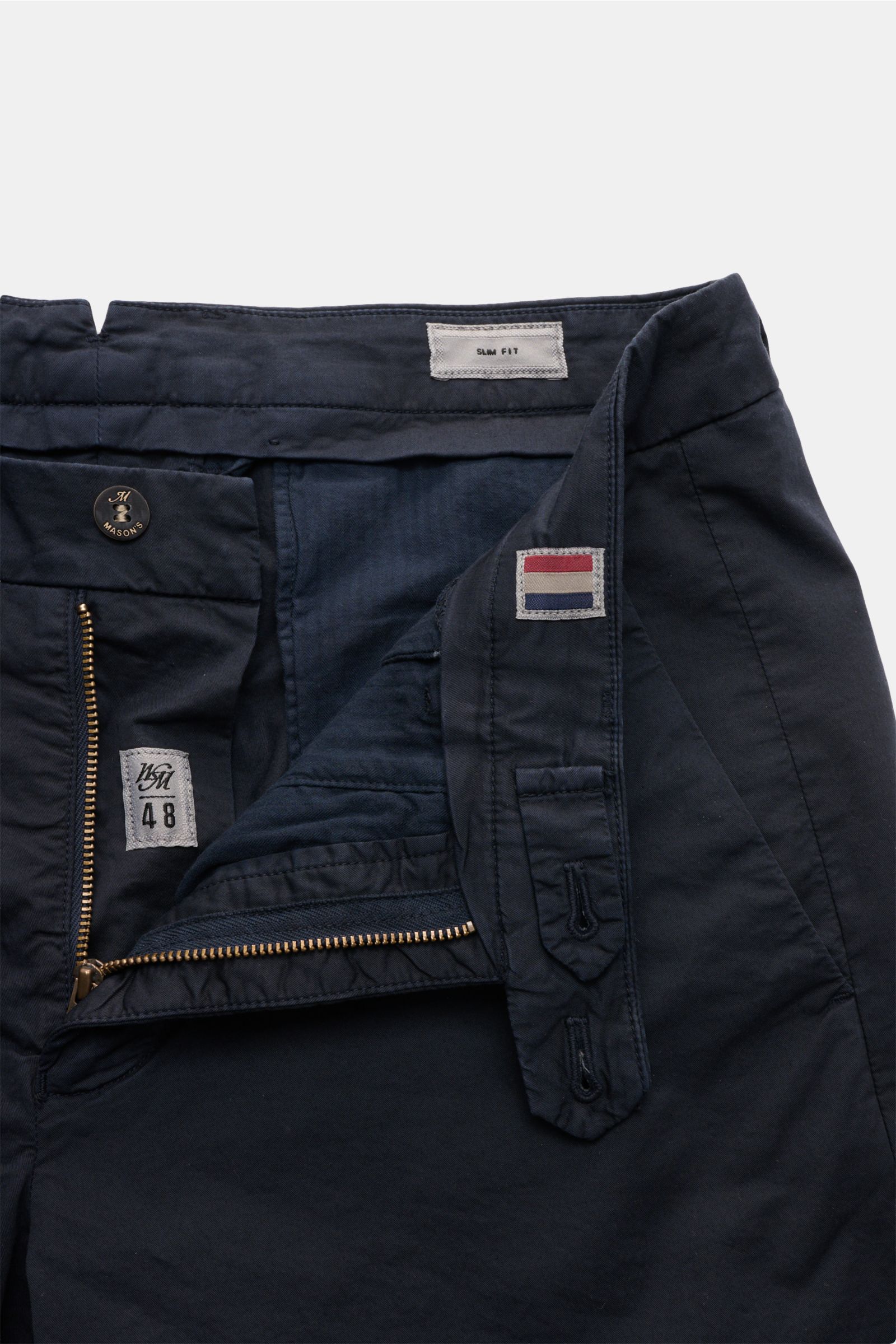 Nahaufnahme der Mason's Shorts 'Torino' navy von vorne mit offenem Reißverschluss, Bundknopf, französischen Taschen und MASON'S-Weblabel.