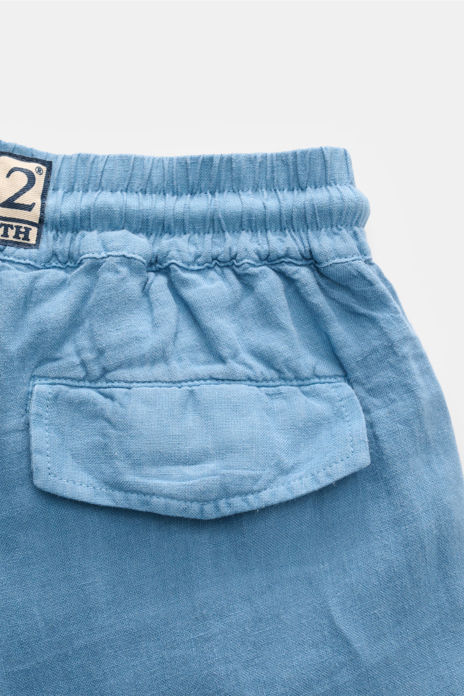 MC2 Saint Barth Linen cargo shorts 'Marseille' smoky blue shown from a close-up rear perspective, highlighting elasticated waistband, back flap pocket, and woven label. Lightweight, garment-dyed linen fabric with typical texture, regular fit, drawstring c
