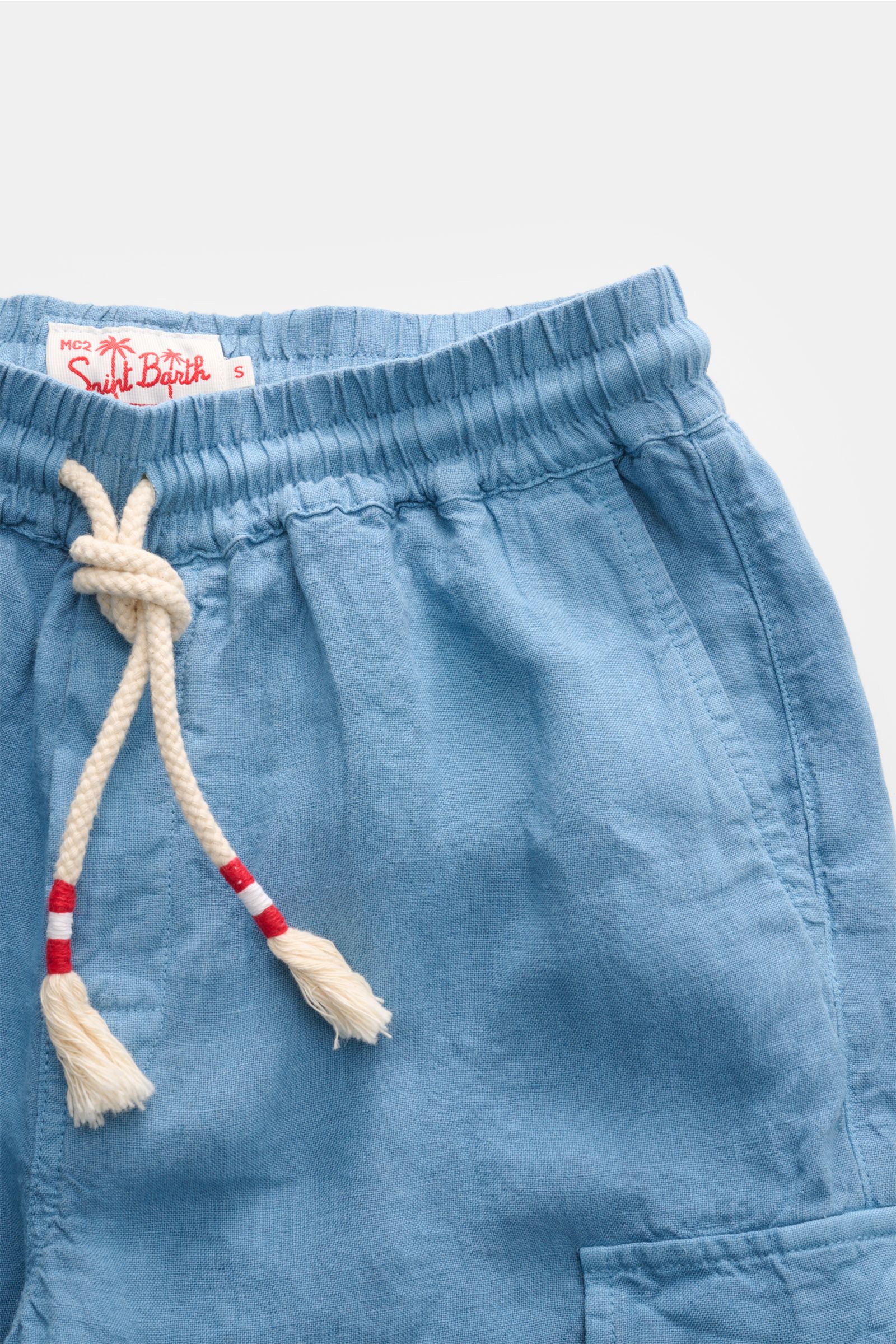 Close-up front view of MC2 Saint Barth Linen cargo shorts 'Marseille' smoky blue, showing elastic waistband, white drawstring with red accents, French pocket, and woven label inside.